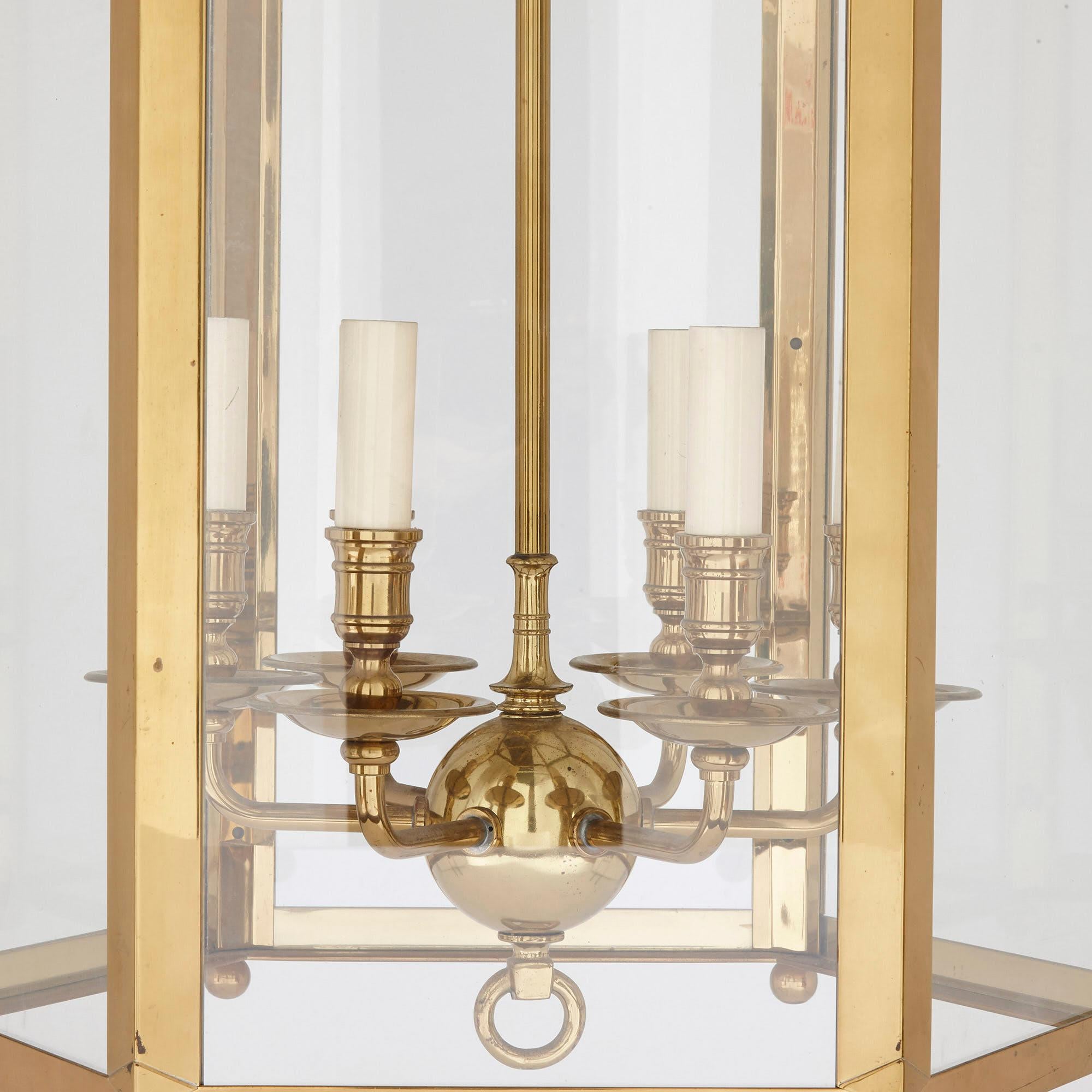 Large neoclassical style brass and plate glass lantern,
French, 20th century
Dimensions: Height 119cm, diameter 64cm

Made from polished brass and plate glass, this large lantern is finely crafted in the neoclassical style. It is supported by