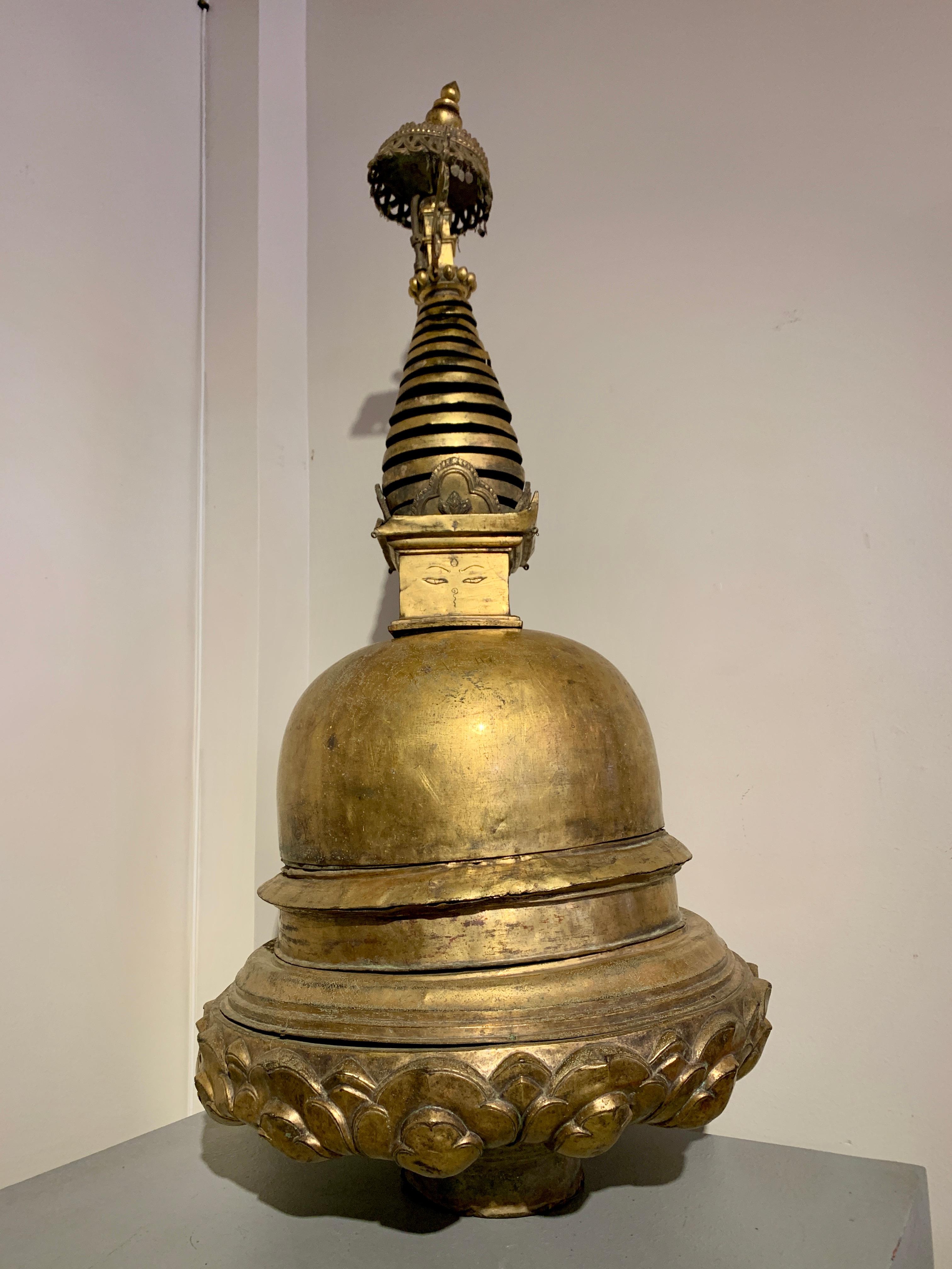 A spectacular large Nepalese stupa, of cast and repousse gilt bronze or copper alloy, 16th/17th century, Nepal.

The magnificent stupa of traditional form, featuring a stylized lotus base supporting a large dome. A square structure, called a