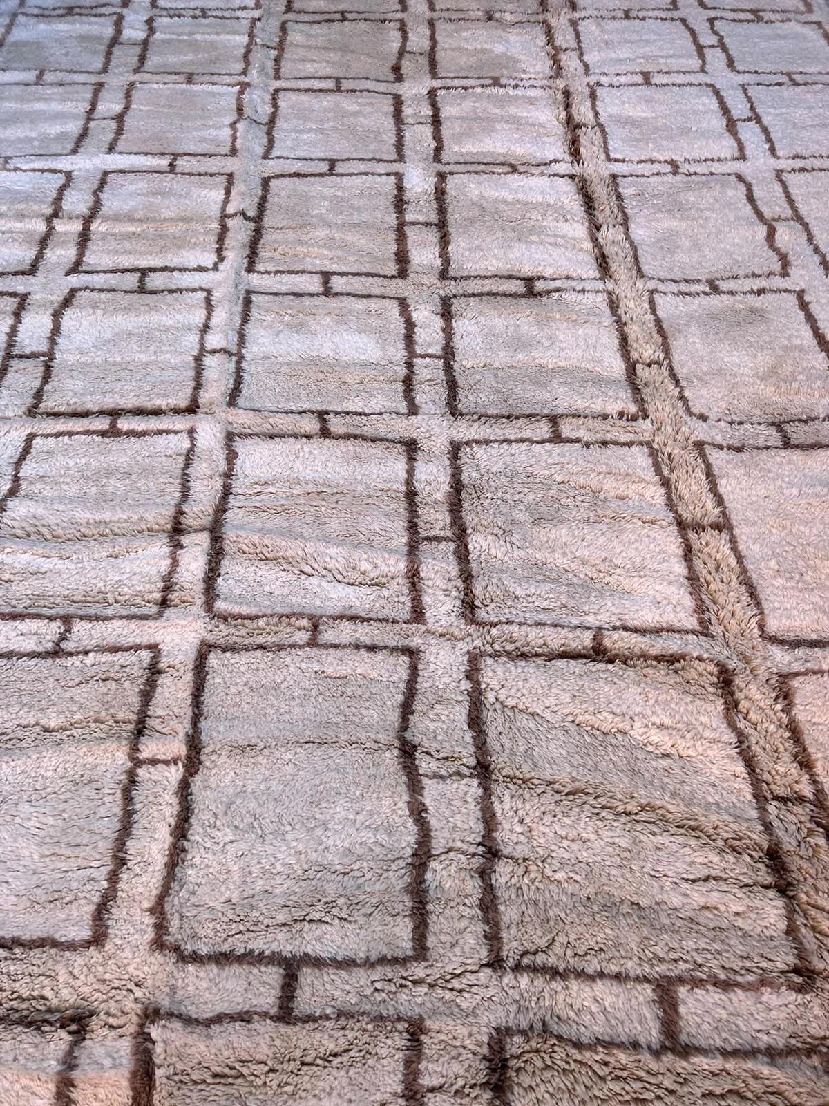 Dieser große, neutrale, handgewebte marokkanische Teppich wurde von geschickten Kunsthandwerkern im Atlasgebirge handgefertigt. Es besteht aus einer hochwertigen, farbenfrohen, neutralen Wollunterlage mit einem verschlungenen