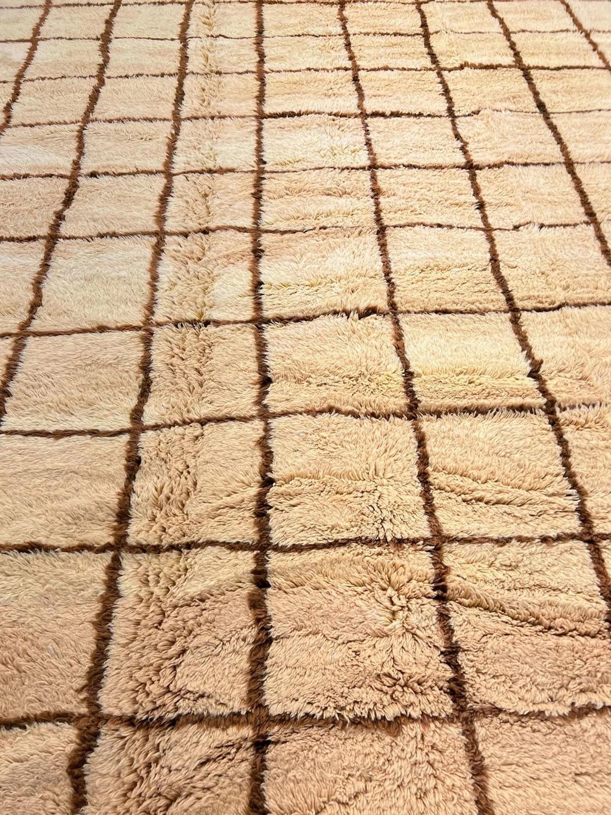 This large, neutral handwoven Moroccan rug was made by hand by skilled artisans in the Atlas Mountains. It features a high quality, richly colored warm neutral wool base with a chocolate tattersall or grid pattern. Handmade on a loom using plush