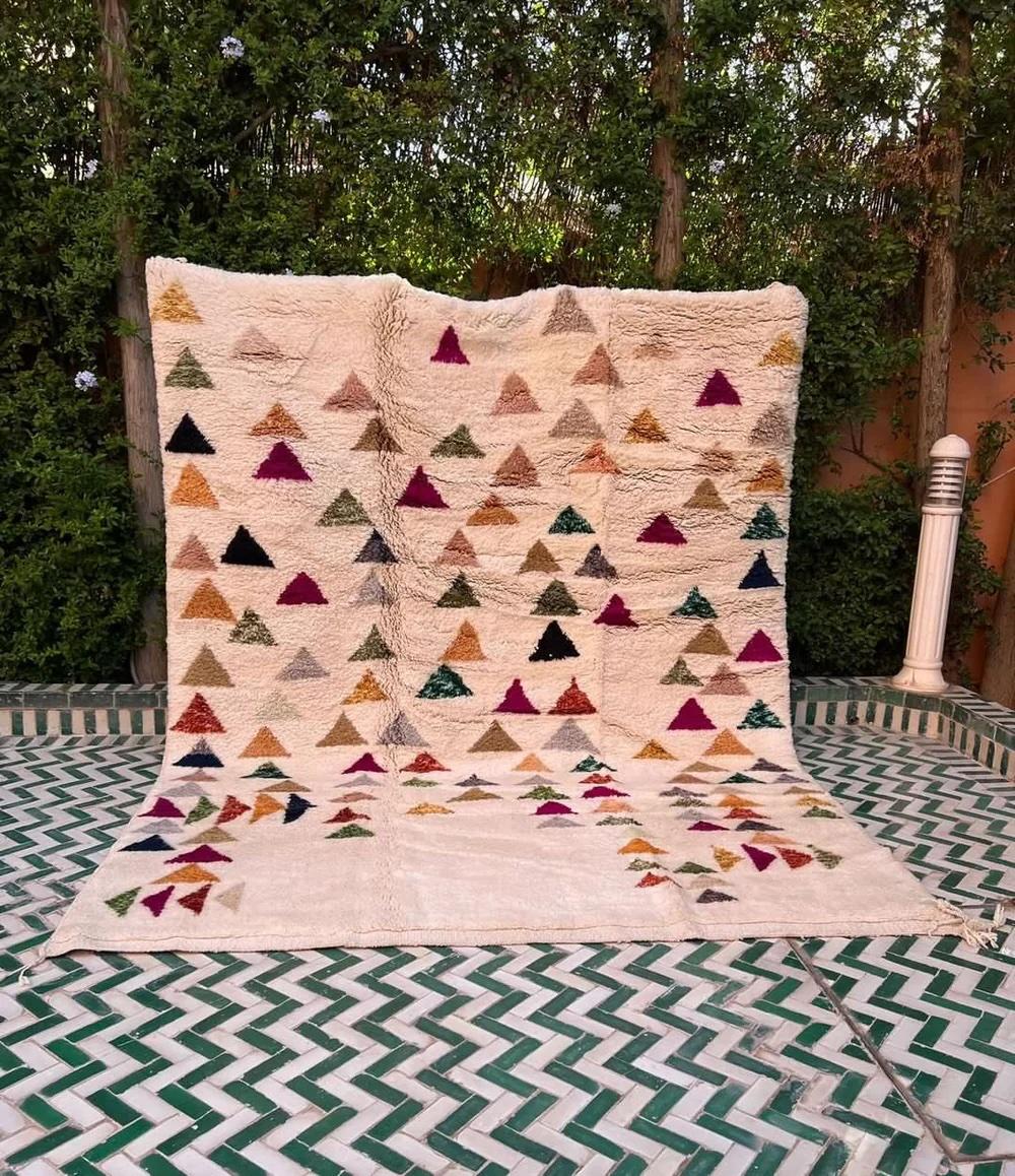 Questo grande tappeto marocchino neutro tessuto a mano è stato realizzato da abili artigiani nelle montagne dell'Atlante. Presenta una base di lana neutra color crema di alta qualità con un disegno geometrico astratto multicolore e simile a un