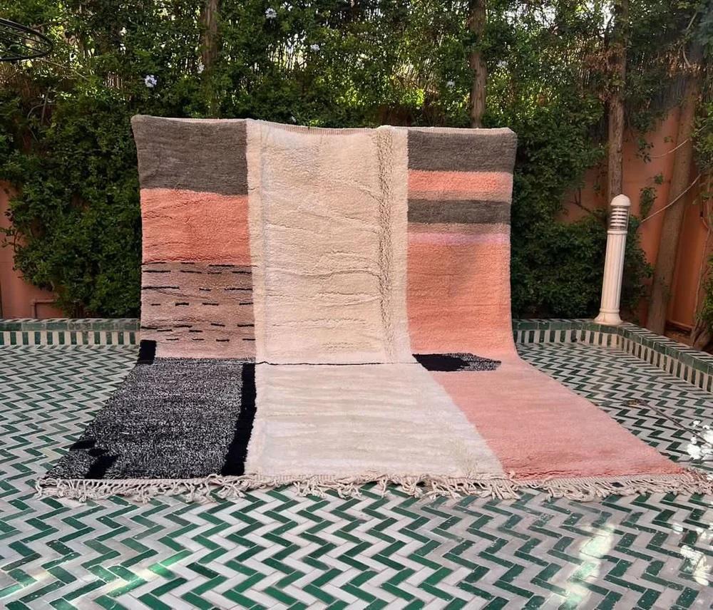 This large, modern handwoven Moroccan rug was made by hand by skilled artisans in the Atlas Mountains. It is handmade with ultra high quality wool, and features a multi-colored striped and colorblocked design unique to Moroccan style. Handmade on a