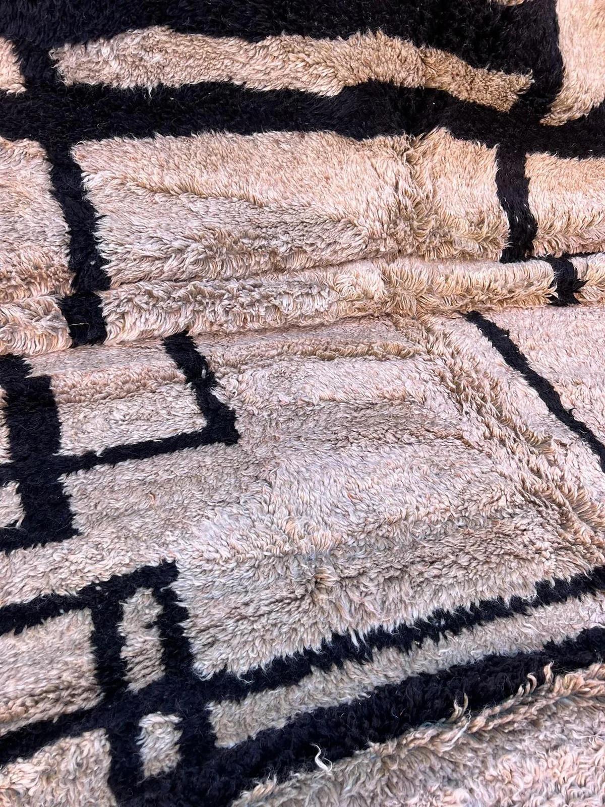 Esta gran alfombra marroquí de color topo fue confeccionada a mano por hábiles tejedores en la cordillera del Atlas utilizando la lana M'Rirt más suave y de mayor calidad. El estilo es un guiño a lo mejor del diseño abstracto moderno de mediados de