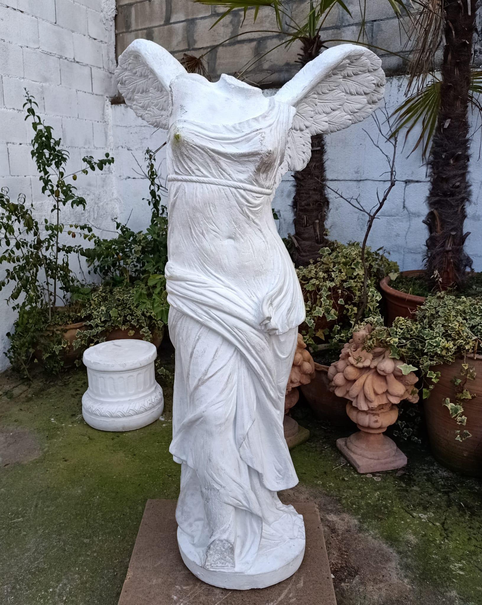 Te presentamos una imponente escultura de jardín que representa a Nike, la diosa griega de la victoria, más conocida como la Victoria Alada de Samotracia. Esta magnífica réplica es de piedra y descansa sobre una base que imita una columna, lo que le