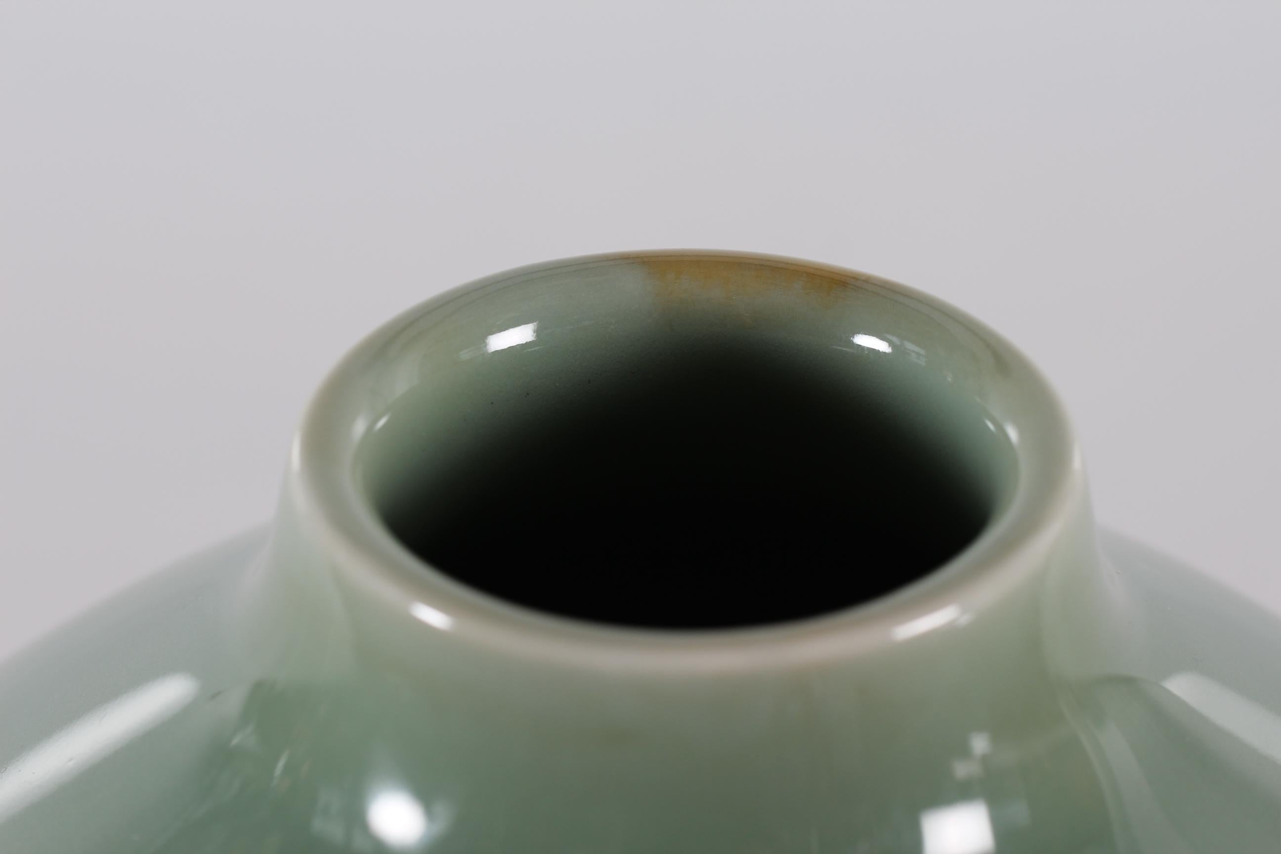 Unique large fine art vase by Nils Thorsson manufactured by Royal Copenhagen in Denmark in the 1950s
It features a stylized decor of eelgrass with glossy celadon glaze is dusty green.

Marked on bottom with 3 waves for Royal Copenhagen and the