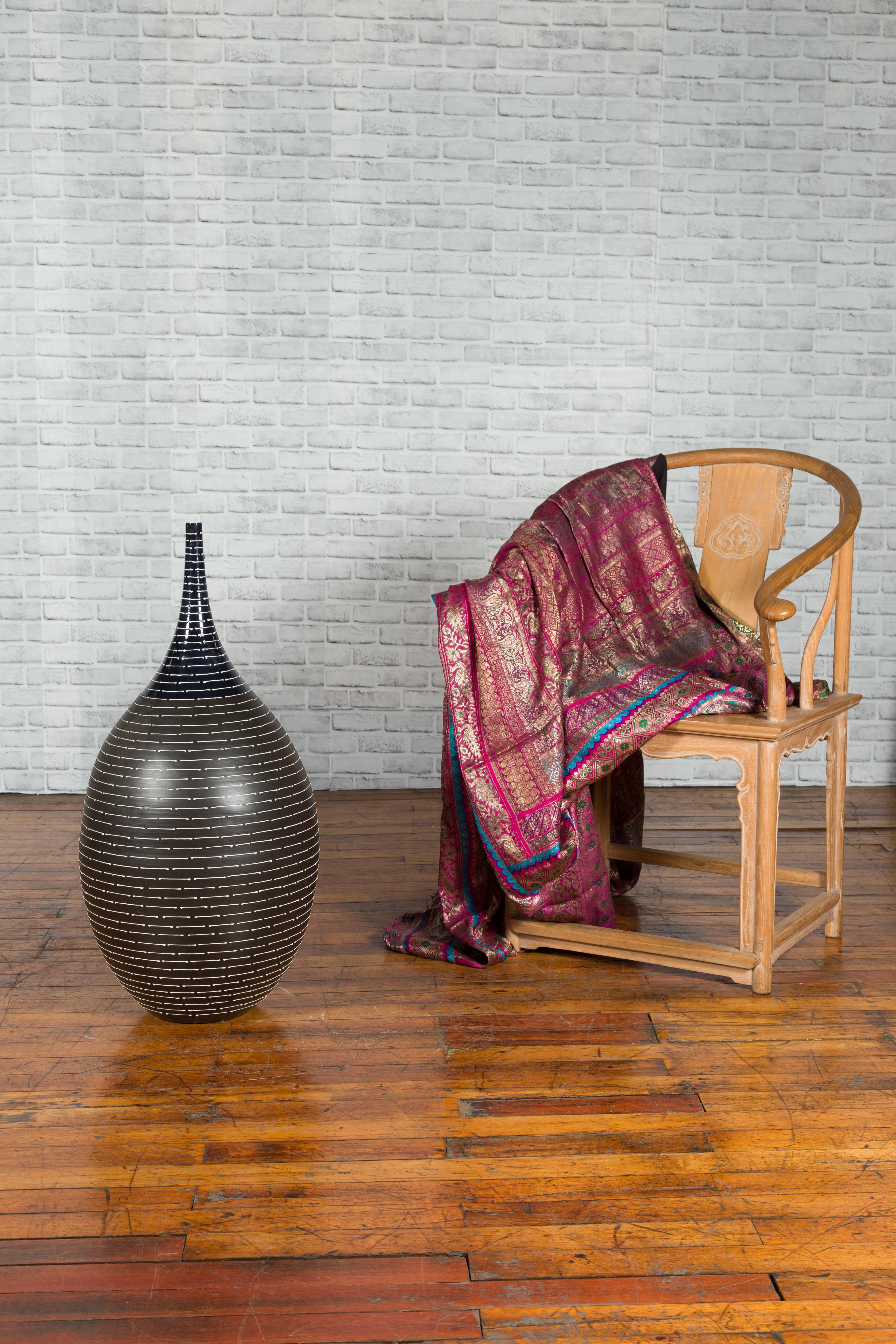 A Thai Chiang Mai contemporary ceramic vase from the Prem Collection with black, white and navy blue tones. Charming our eye with its sleek lines and striated décor, this vase was born in Chiang Mai, northern Thailand. The piece showcases a rounded