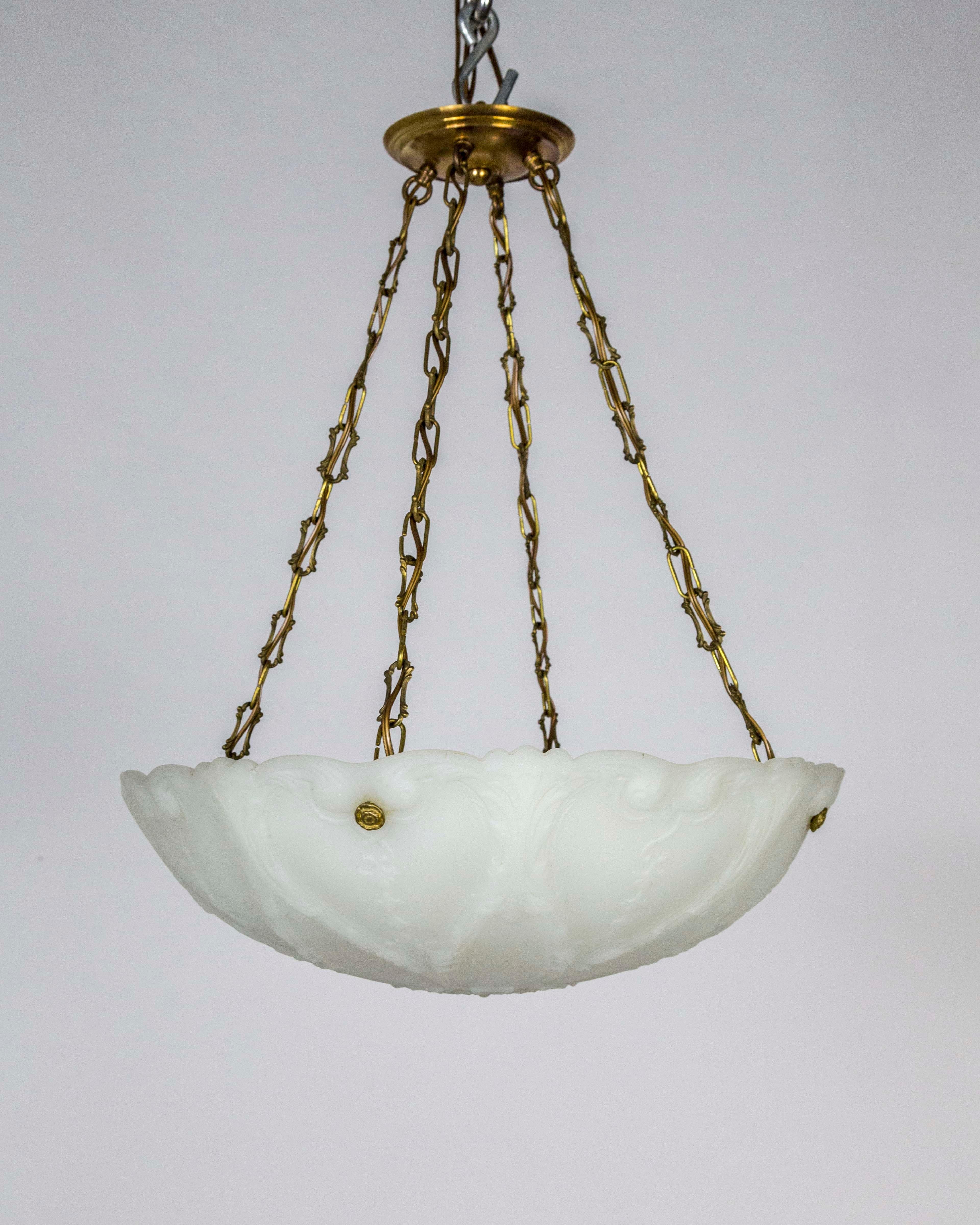 A neoclassical, intricately molded milk glass pendant with Art Nouveau inspired design; early 1900s. Solid brass chain and canopy; 4 medium based, porcelain sockets. 24