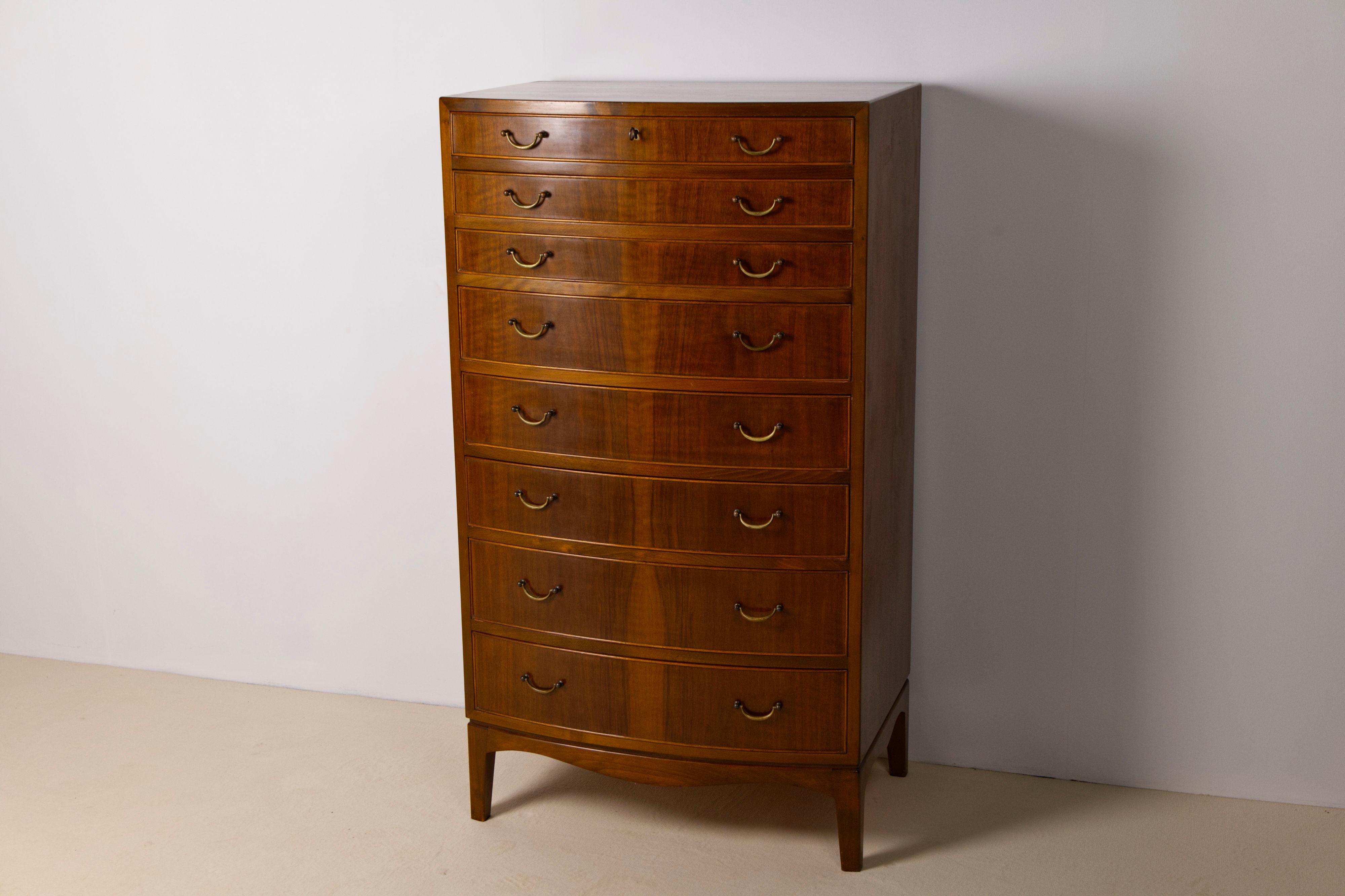Élégante et grande commode conçue par Ole Wanscher pour le fabricant de meubles A.J Iversen au Danemark. La commode comporte huit tiroirs de trois hauteurs différentes, tous plaqués en noyer magnifiquement teinté et munis de poignées en laiton