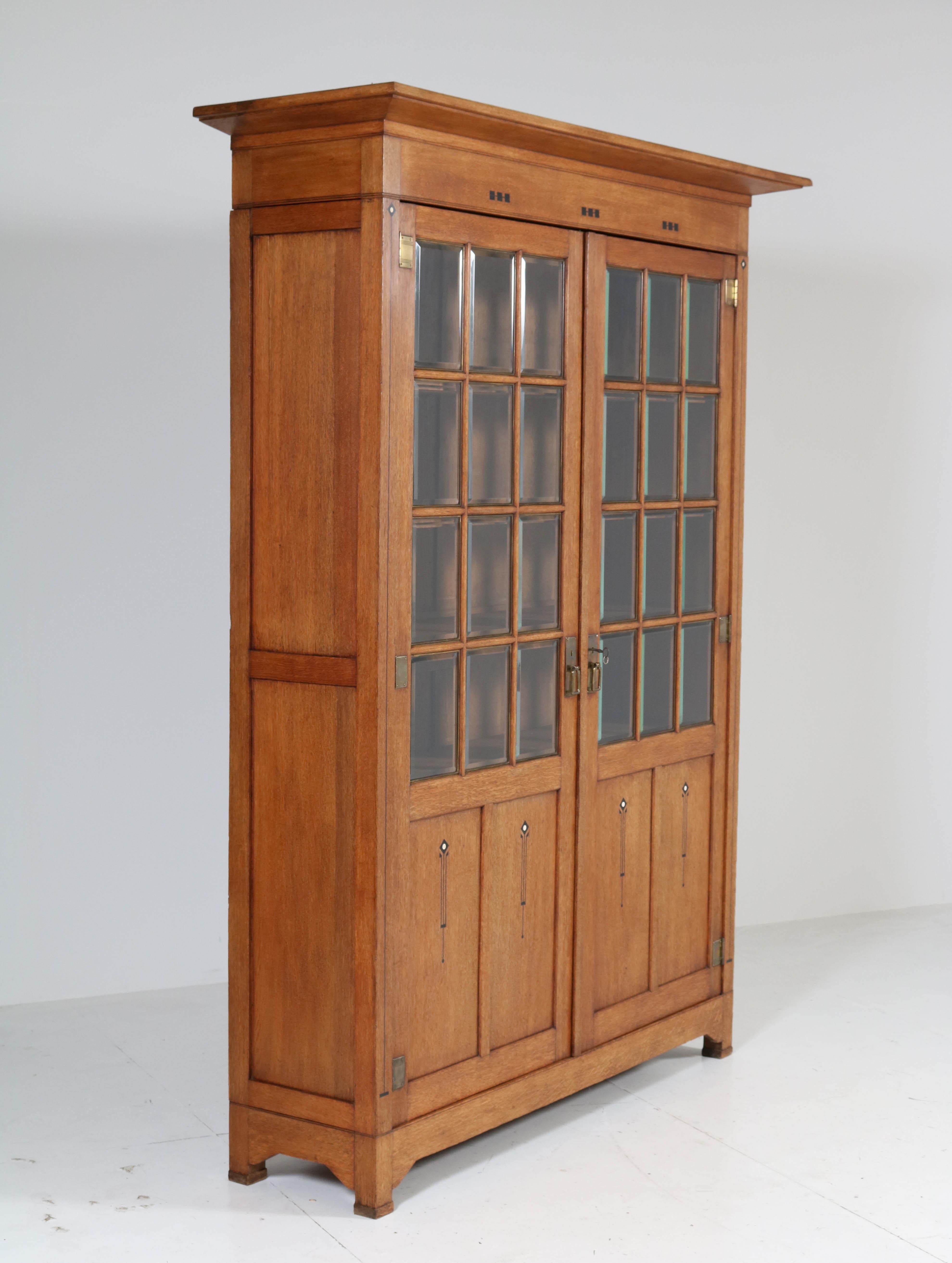 Stunning and rare Arts & Crafts Art Nouveau bookcase.
Striking Dutch design from the 1900s.
Solid oak with original inlay and original beveled glass.
This magnificent piece of furniture can be dismantled for safe transport.
Five original wooden