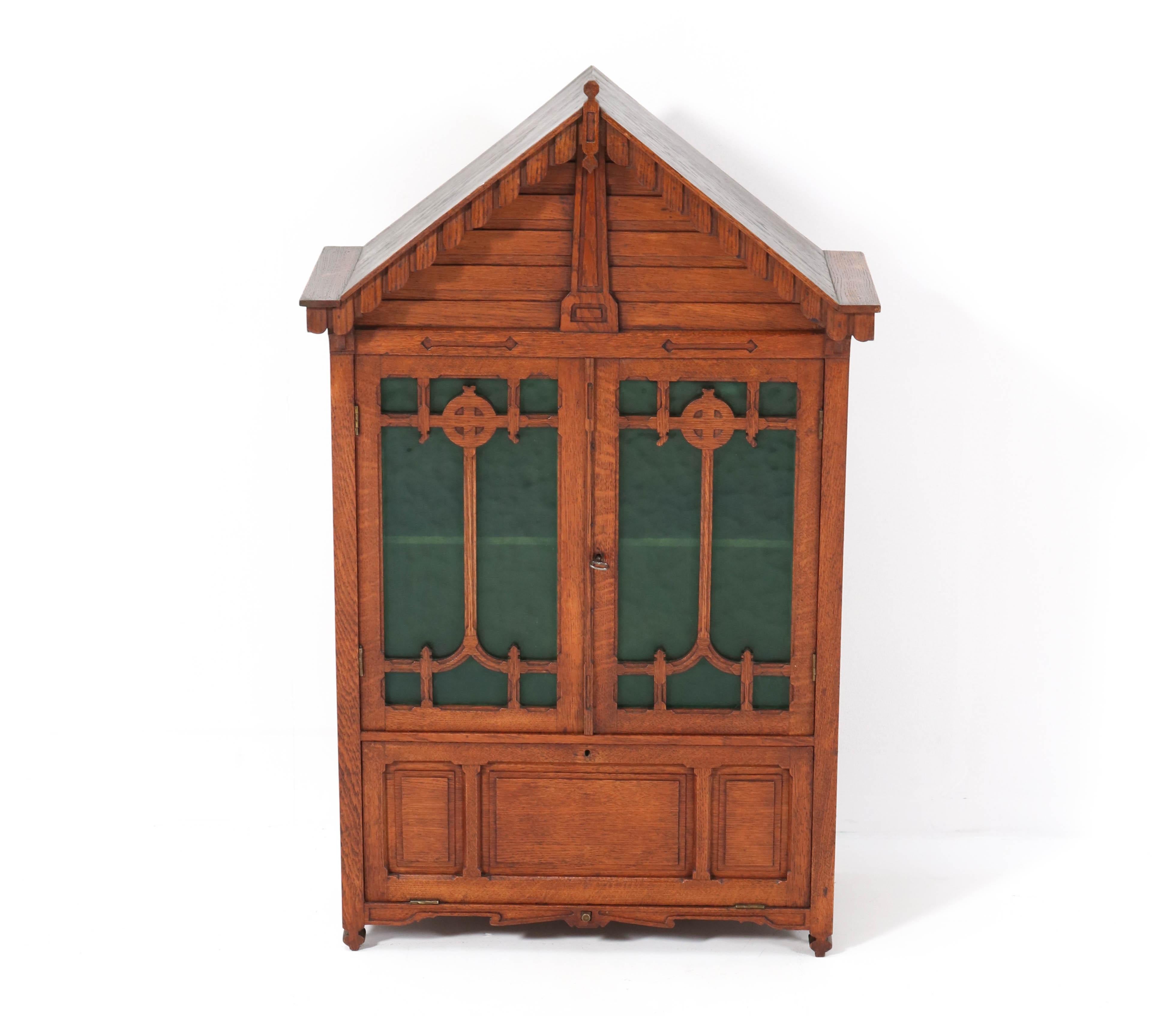 Magnificent and rare large Arts & Crafts wall cabinet.
Striking French design from the 1900s.
Solid oak with original green glass.
Lock and key in good working order.
In very good condition with a beautiful patina.