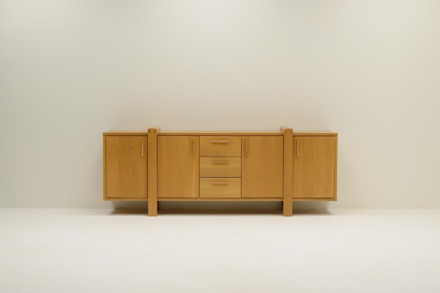 Large Belgium oak sideboard. Mostly made of solid oak. 3 drawers and 4 doors. Behind every door are modular shelfs. In very good vintage condition.

Request a quote for the latest shipping rates.
