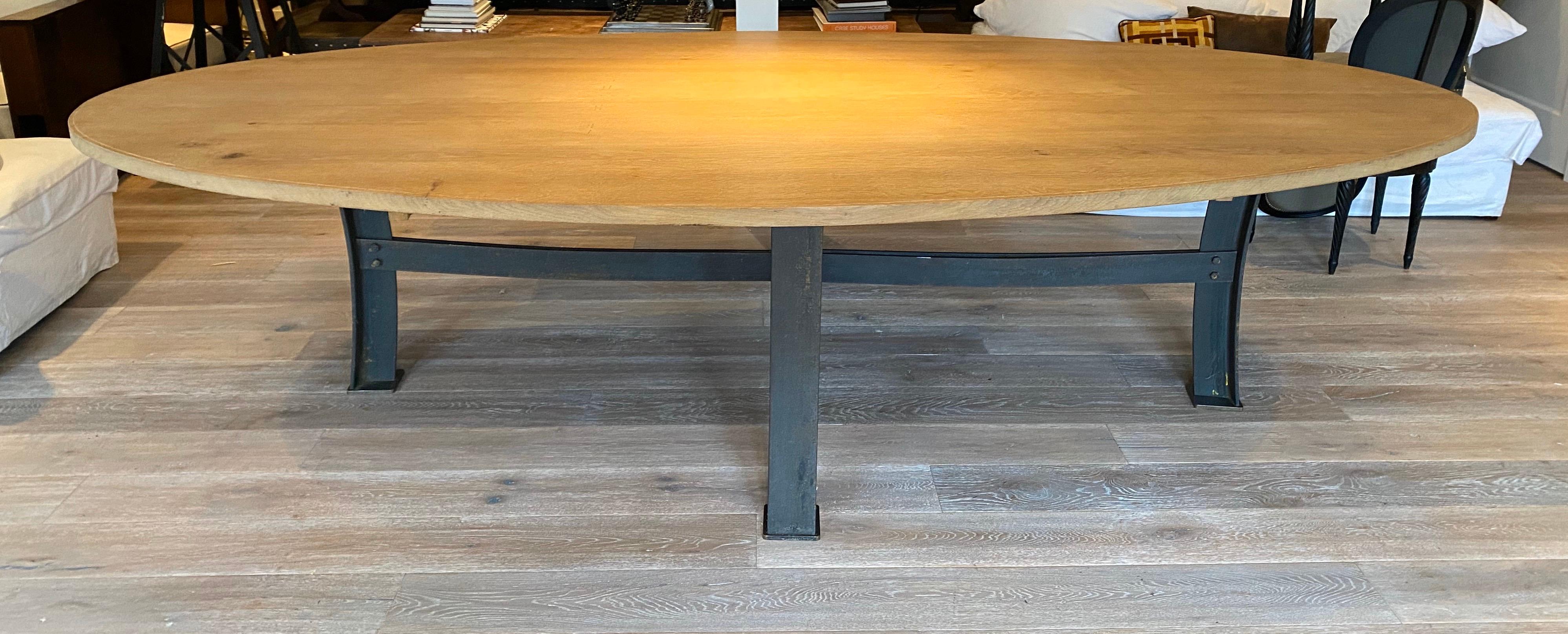 A stunning solid oak oval dining table with steel beam base. Solid and heavy construction. The table comfortable seats 12-14 people. From a New York City townhouse designed by French designer Olivier Gagnère.