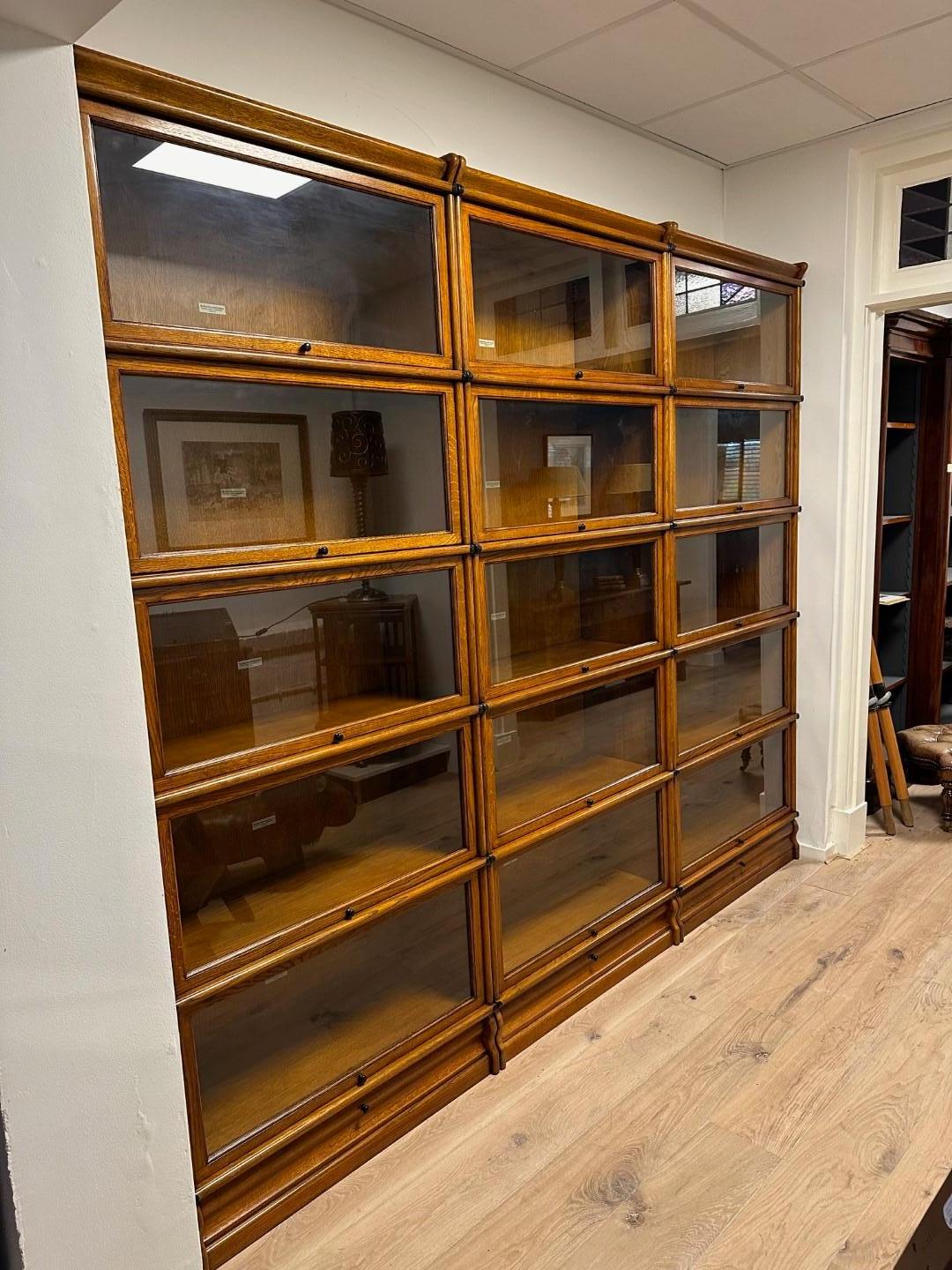 Solid oak Globe Wernicke bookcase. Back and bottom are always plywood in Globe Wernicke Bookcases. Completely made up of 15 stackable parts. Plinths are equipped with drawers. Completely in perfect condition. Top quality.
Size: 258cm x 35cm x