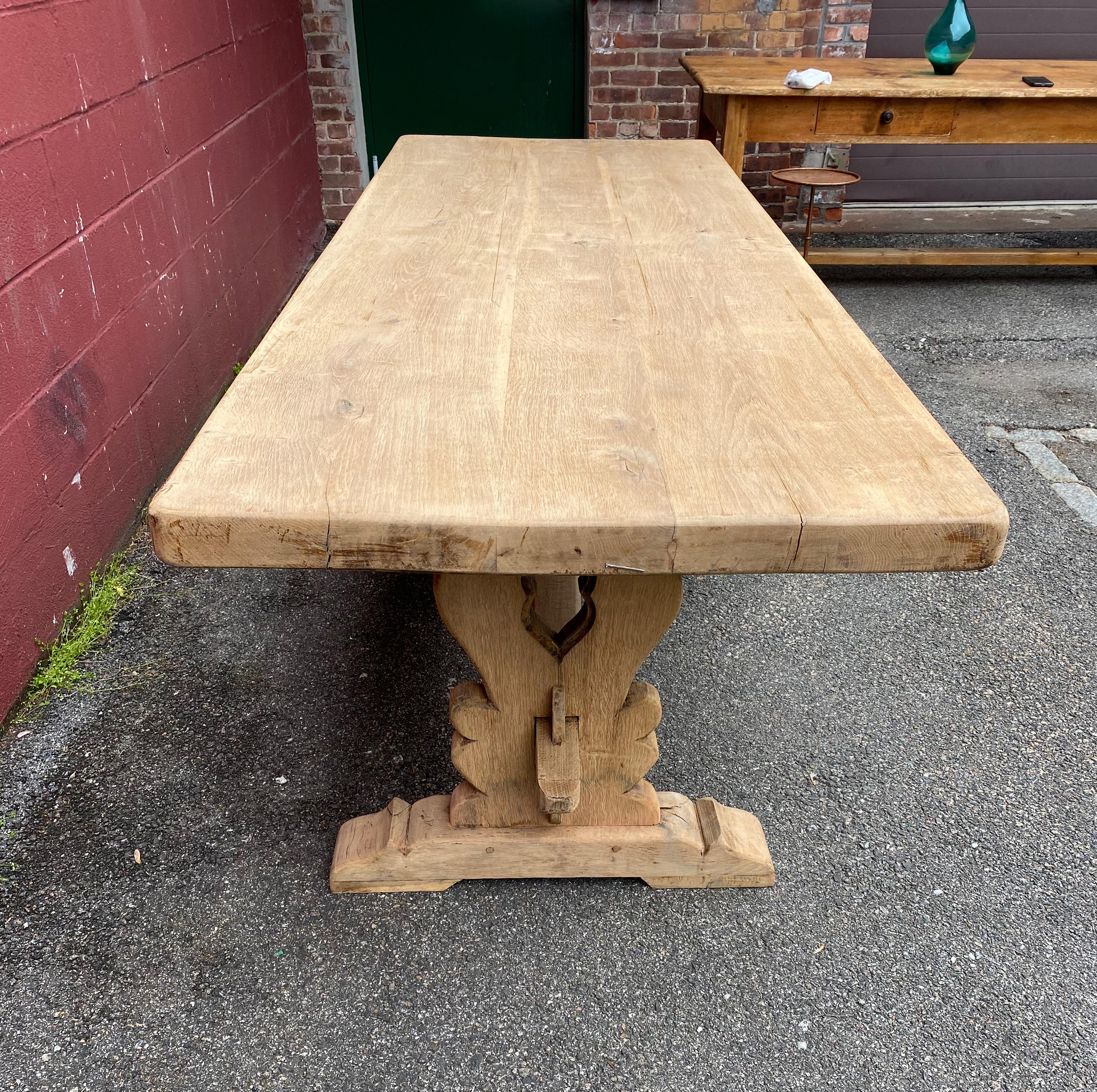 Large French or Italian monastery table made of sold oak. The topic constructed of 3 thick planks of solid oak and it very heavy. The classic monastery style base is joined by a stretcher that is removable for easy breakdown. The table was recently
