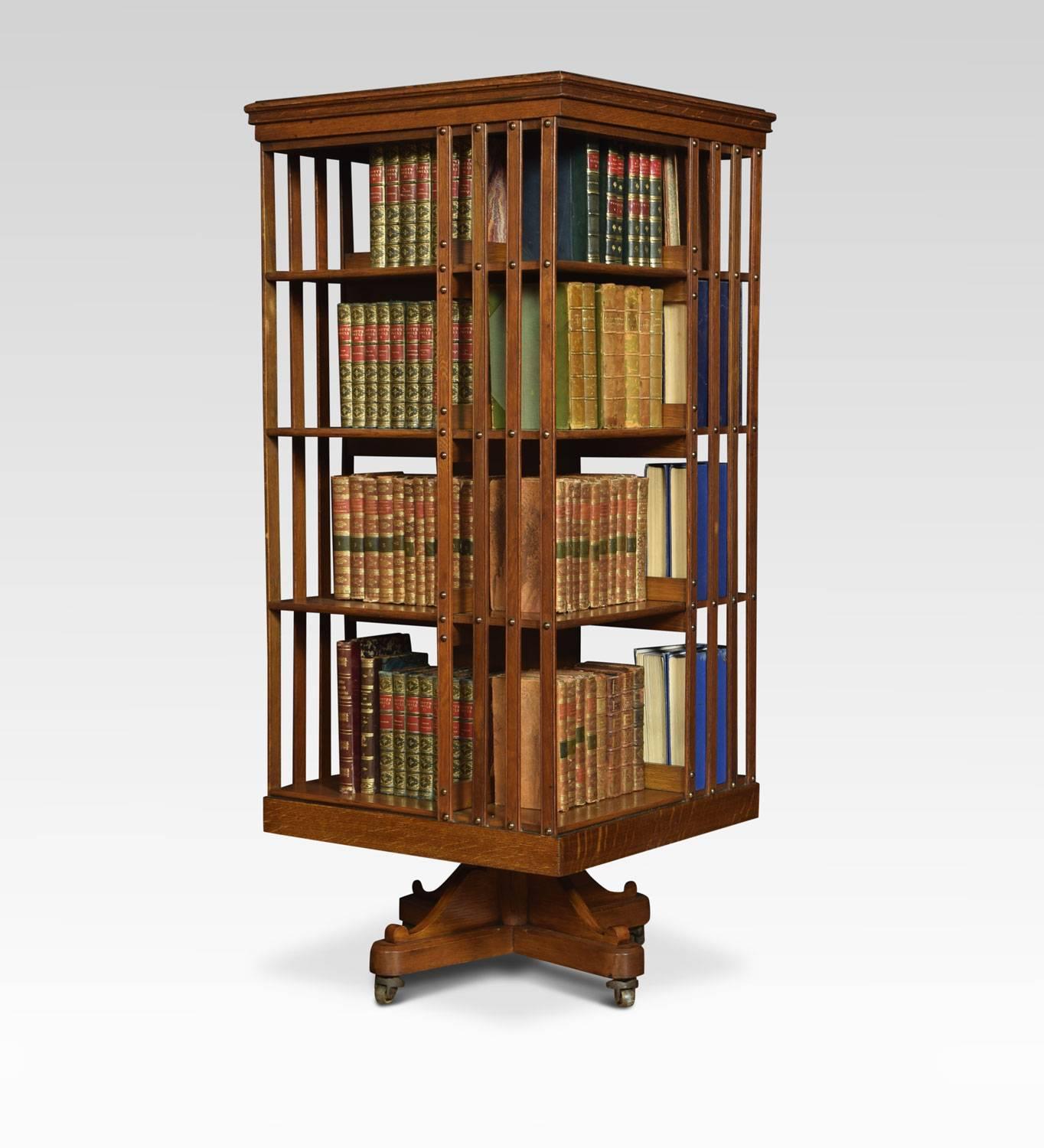 Oak revolving bookcase the square top above four tiers with a arrangement off shelves raised up on cruciform base with castors.
Dimensions:
Height 49 inches
Width 21 inches
Depth 21 inches.