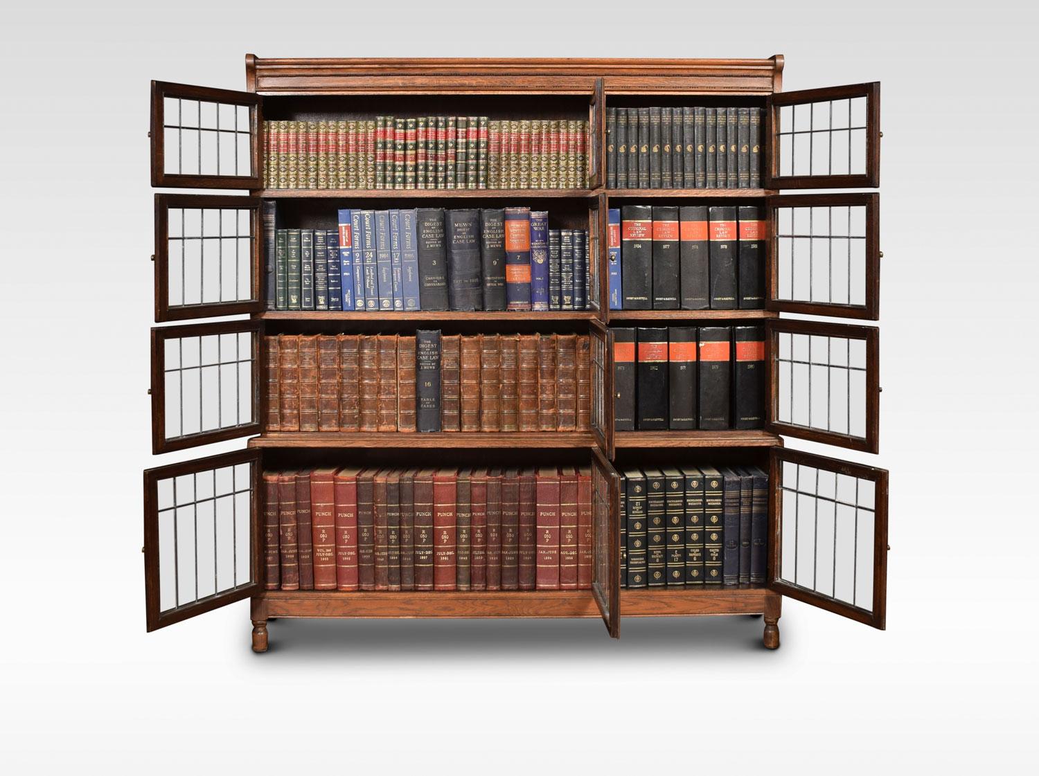Large oak sectional bookcase, the moulded top above four graduated tiers each tier fitted with three leaded glass doors and brass knob handles, All raised up on turned feet.
Dimensions:
Height 59 inches
Width 52.5 inches
Depth 11.5 inches.