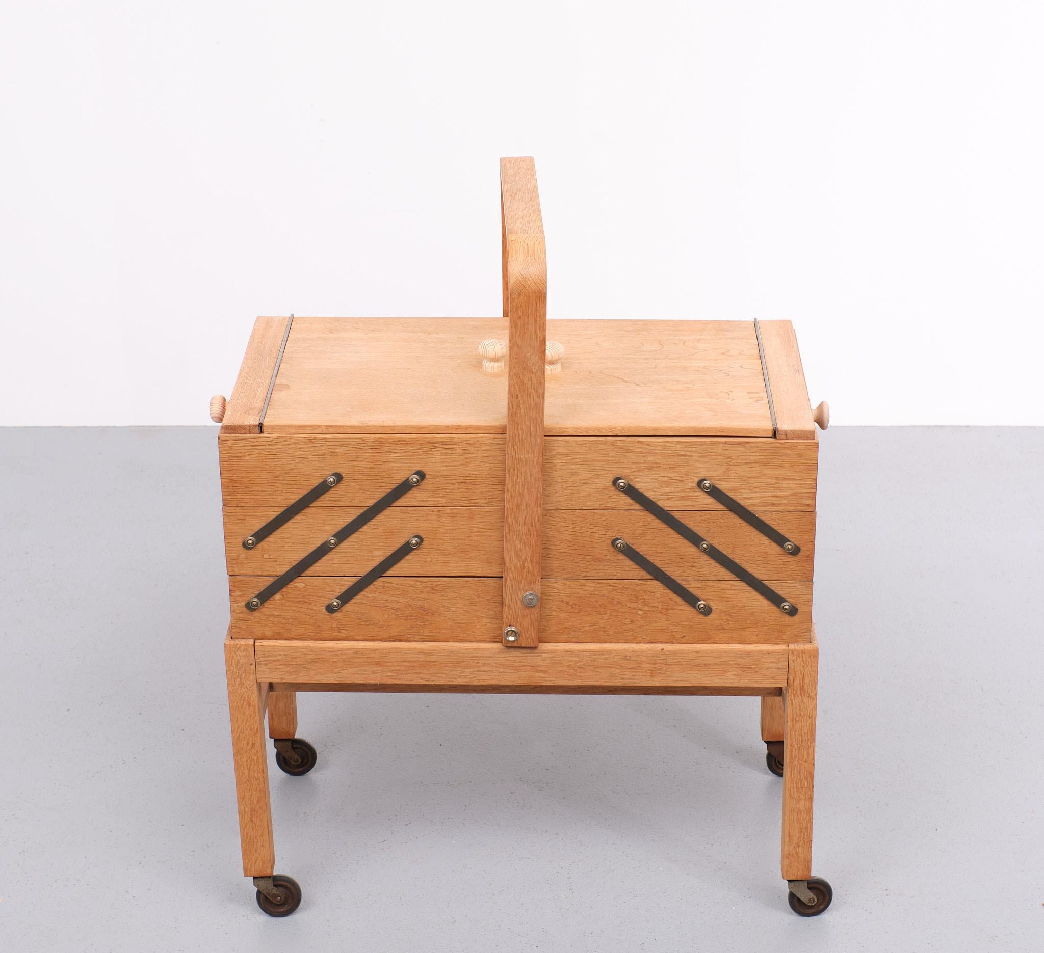 Large Solid Oak wood sewing box ,on wheels . opened with two hinged doors on the top, while the accordion style (with layered shelves that used external hinges to store more stuff in a compact space) Useful for serious sewers or other hobby's or
