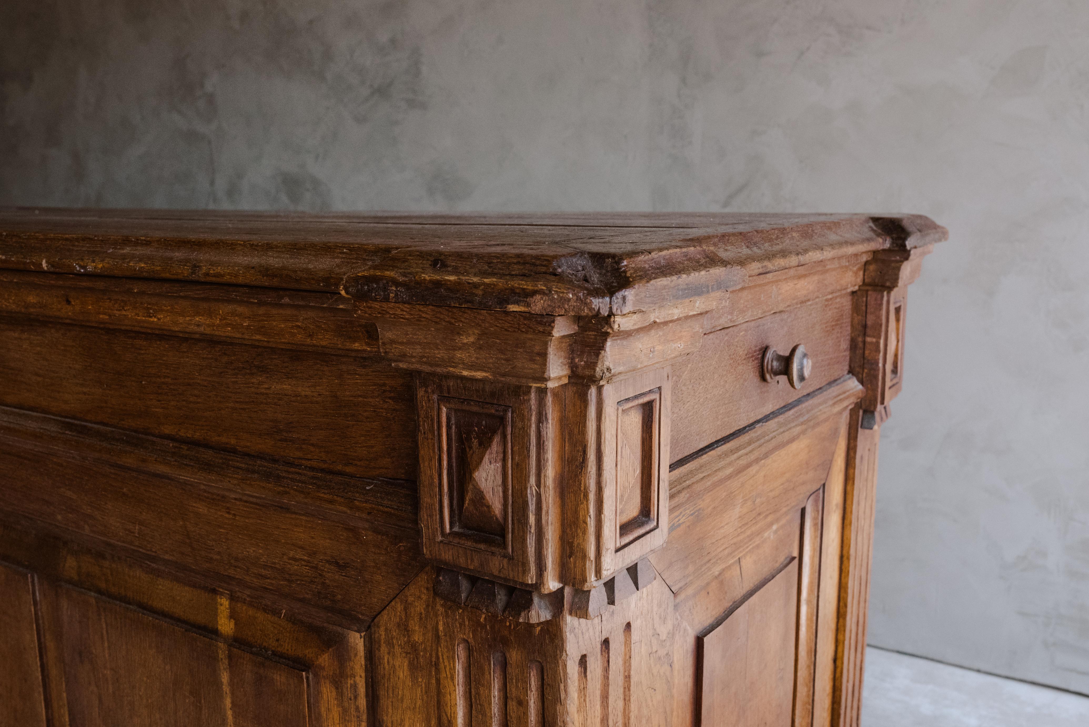 Large oak shop counter from France, Circa 1880. Nice model with intricately carved details. One drawer on each end and shelf in the back. Very nice wear and patina.
