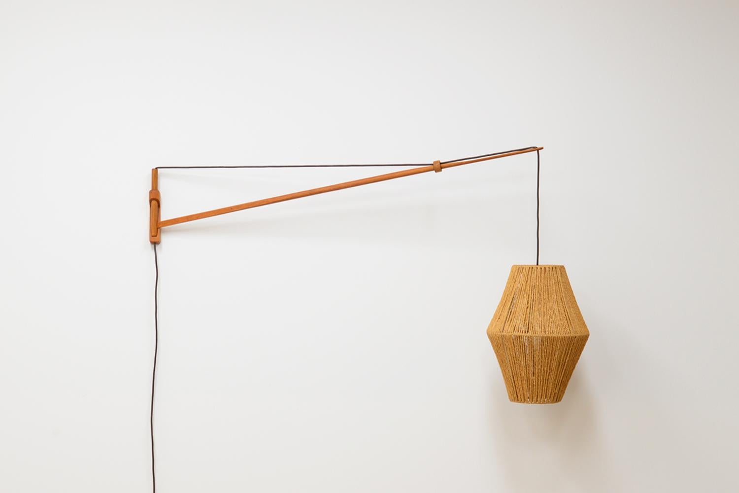 Large oak wall lamp by A. Bank Jensen & Kjeld Iversen for Louis Poulsen 50’s. The lamp can be adjusted to the left and right and up and down simply by pulling or releasing the wire. The lamp has a papercord shade. In very good vintage condition.