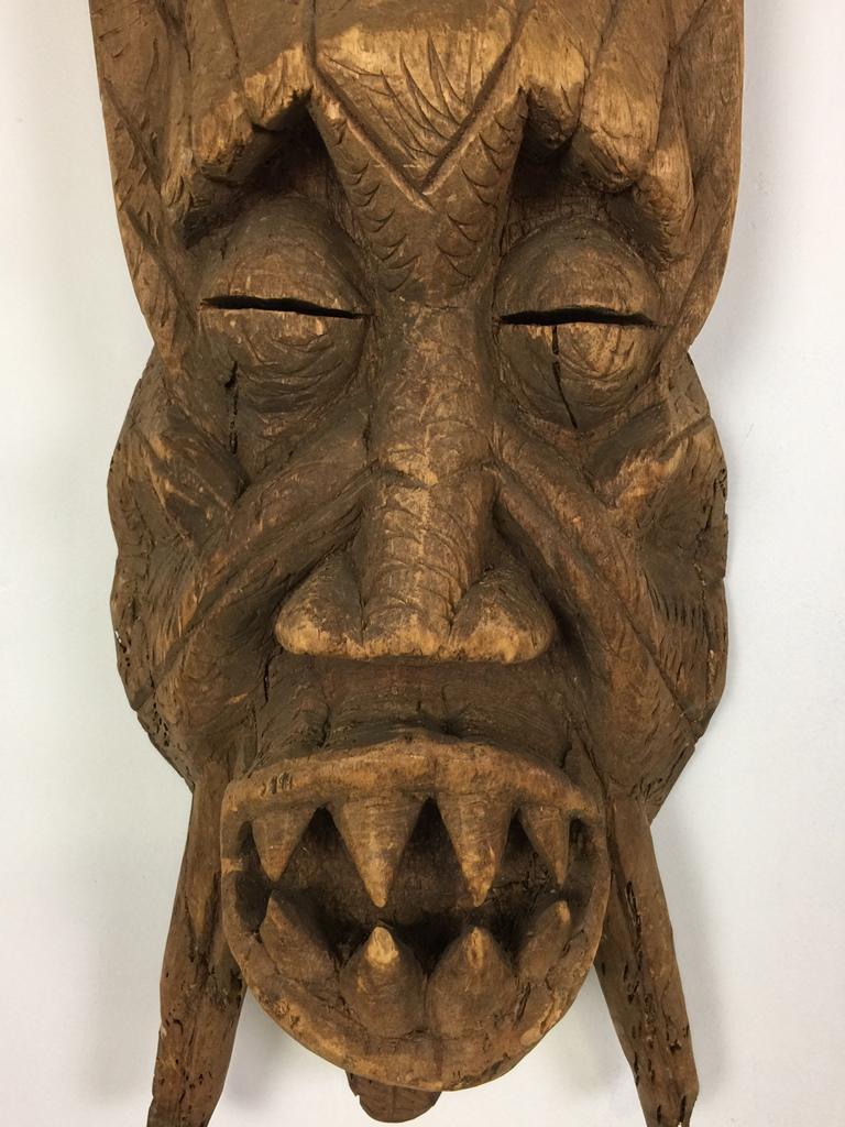 A rather large, frightening and strange mask. We are not quite sure what region or country this is from but our best guess is that it is from an Oceanic tribe of the Pacific Ocean. It is made of relatively light wood and comes from the tribal art