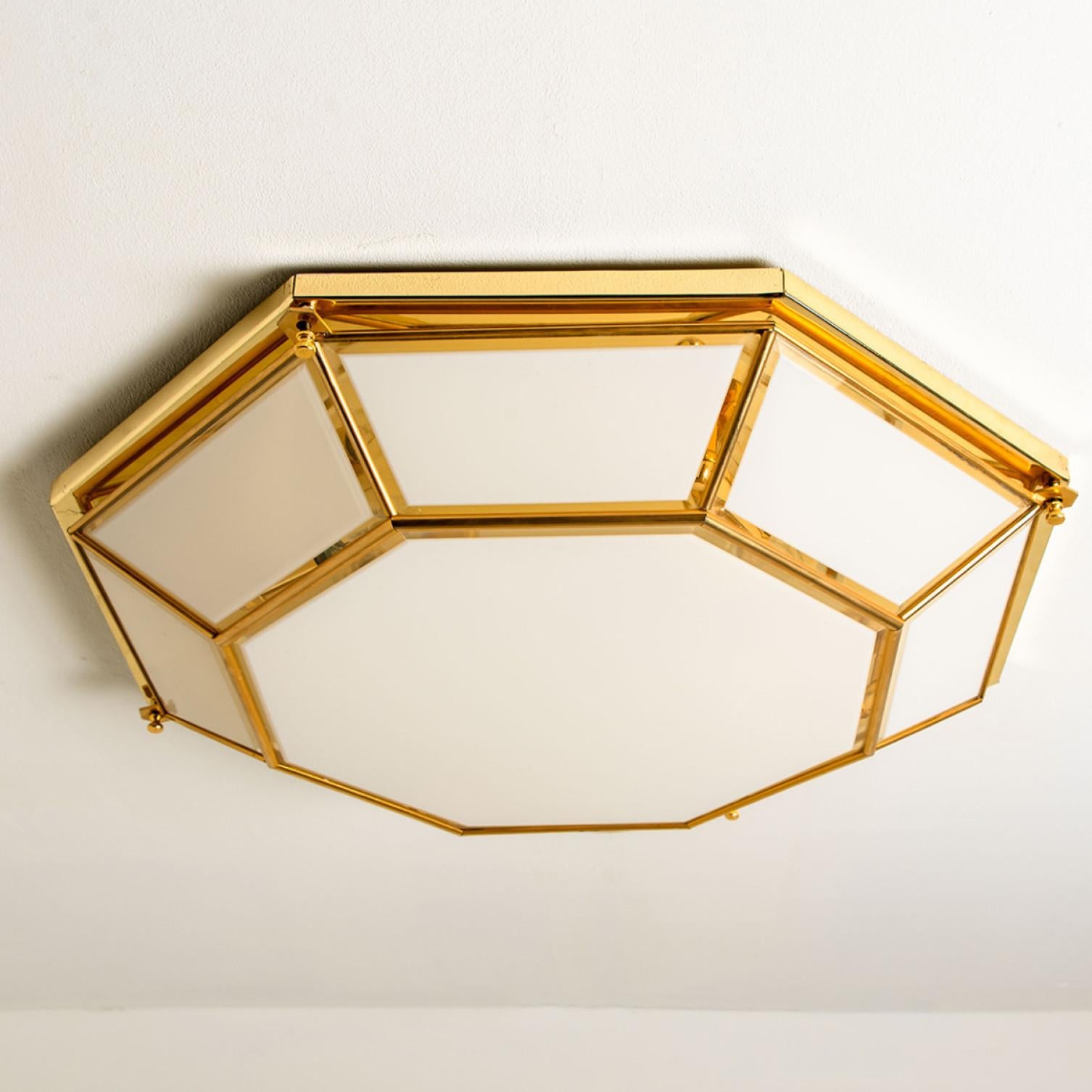 This beautiful and unique octagonal glass light flush mount or wall light is manufactured in Germany, during the 1970s, (early 1970s). Nice craftsmanship. Minimal, geometric and simply shaped design. Opal glass with brass frame.

Designed as