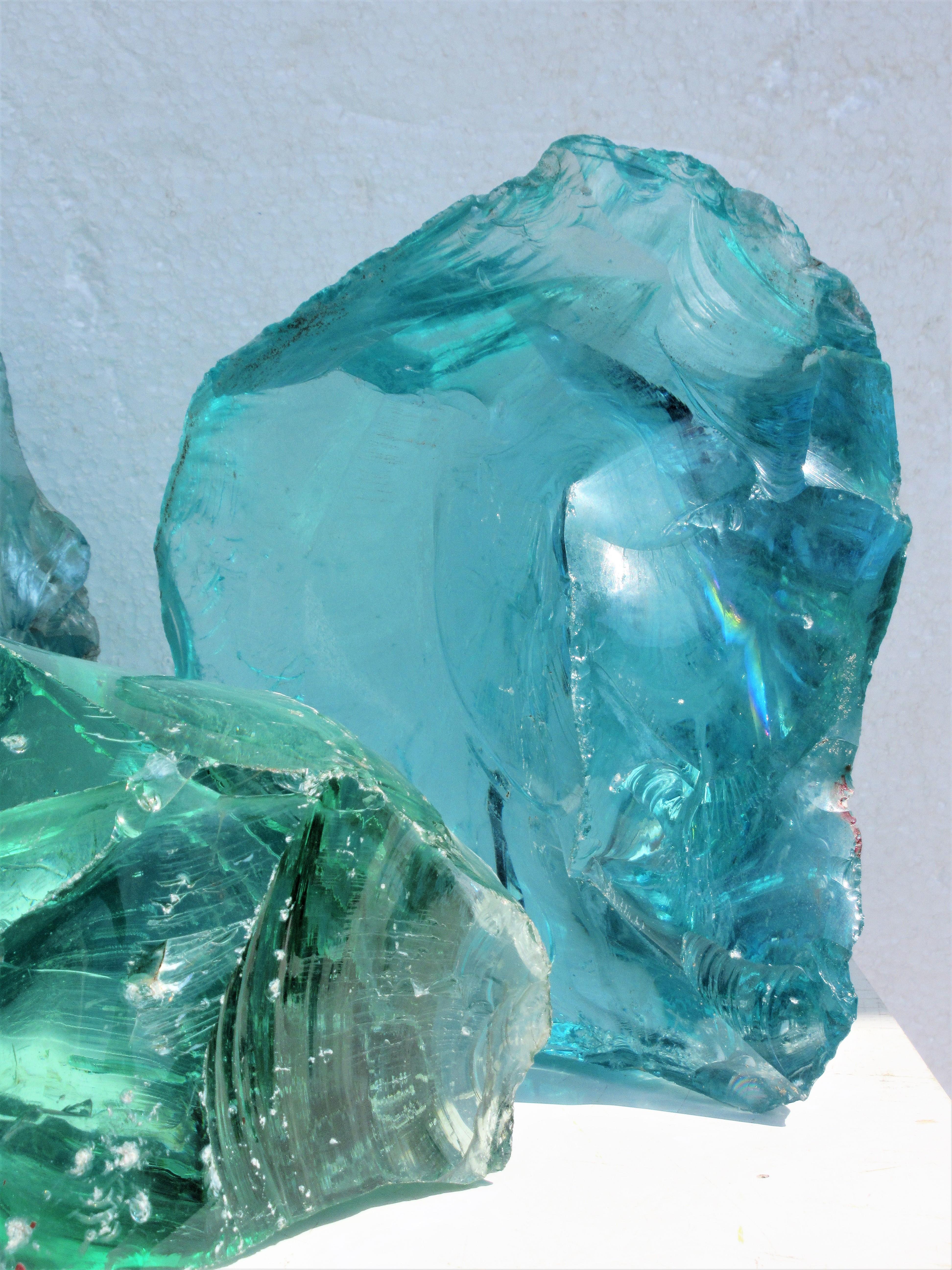 A group of three large old freeform cullet factory glass chunks. Two aqua and one green. Tallest size (right side rear) aqua, 10 inches h x 8 1/2 inches wide x 4 inches deep. Middle size (left side rear), aqua, 8 inches high x 9 1/2 inches wide x 5