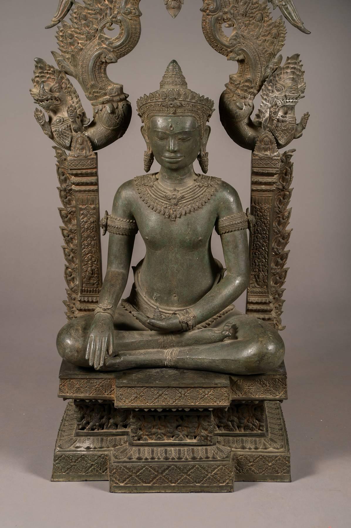 Large old Cambodian bronze temple Buddha. Having very detailed bronze work, the piece comes apart into approximately seven pieces. It has an old greenish patina throughout the bronze. The piece is quite tall standing at 69