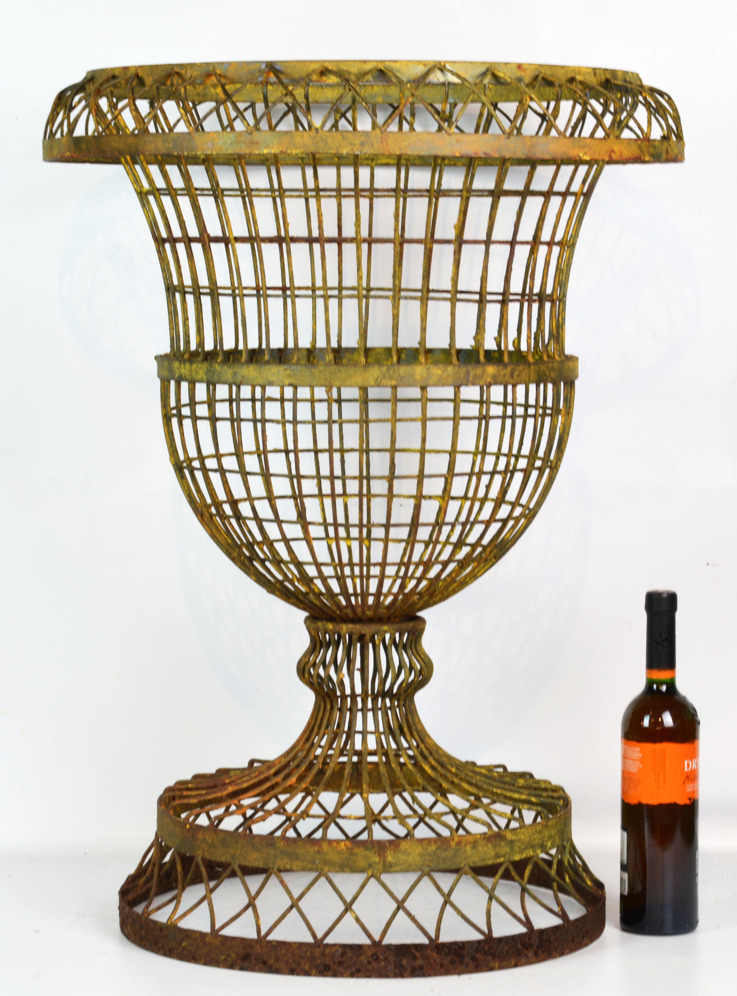 Standing 32 inches tall this French style wire garden urn is spectacular. The urn planter has formerly been painted. The paint has been partially removed leaving the urn with a beautiful distressed look.
