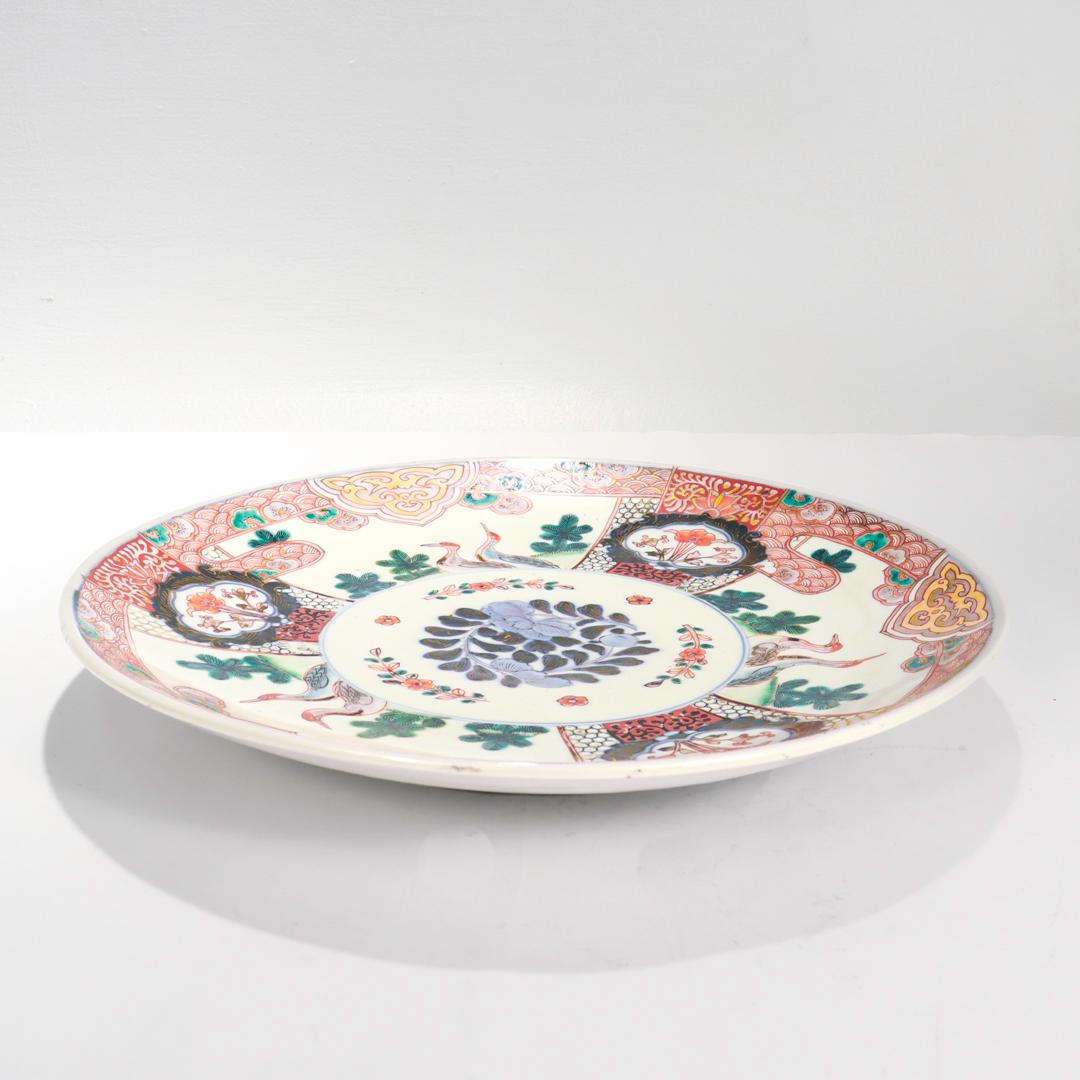 A fine old or antique Japanese Imari porcelain tray.

With red, blue and green painted decoration and gilt accents throughout.

The bowl has three panels depicting a pair of mandarin ducks and foliage with blue and red floral cartouches between the