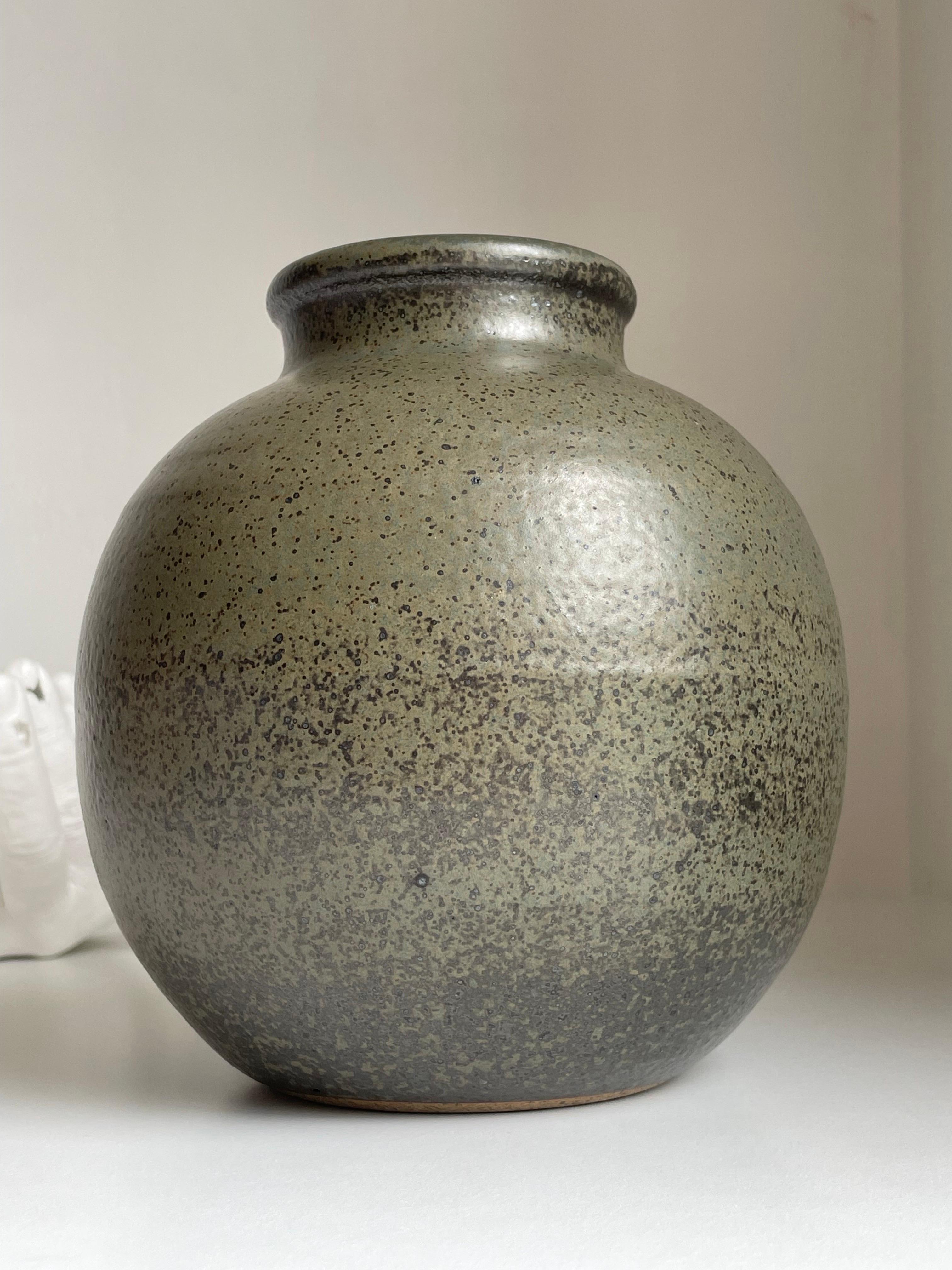 Grande vaso circolare in ceramica della metà del secolo scorso con uno smalto sorprendente nei colori verde oliva, blu chiaro e marrone caldo e nerastro. Piccolo timbro su un lato. Eccellenti condizioni vintage. 
Danimarca, anni '60.