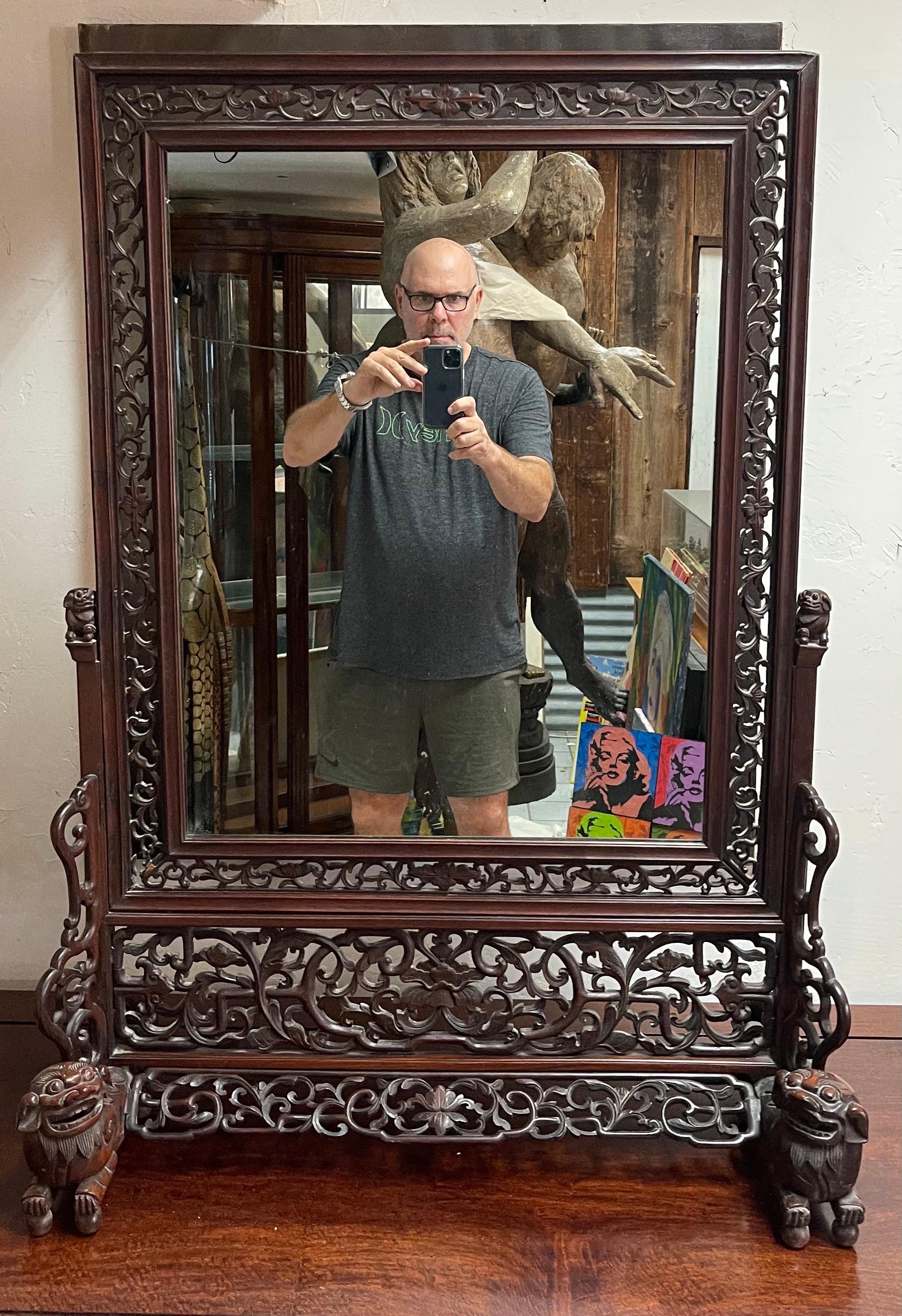 Incredible large one-of-a-kind Chinese rosewood table mirror with foo dogs & lattice work, circa 1920s. This mirror is gorgeous! It is in very good vintage condition and measures 31.5