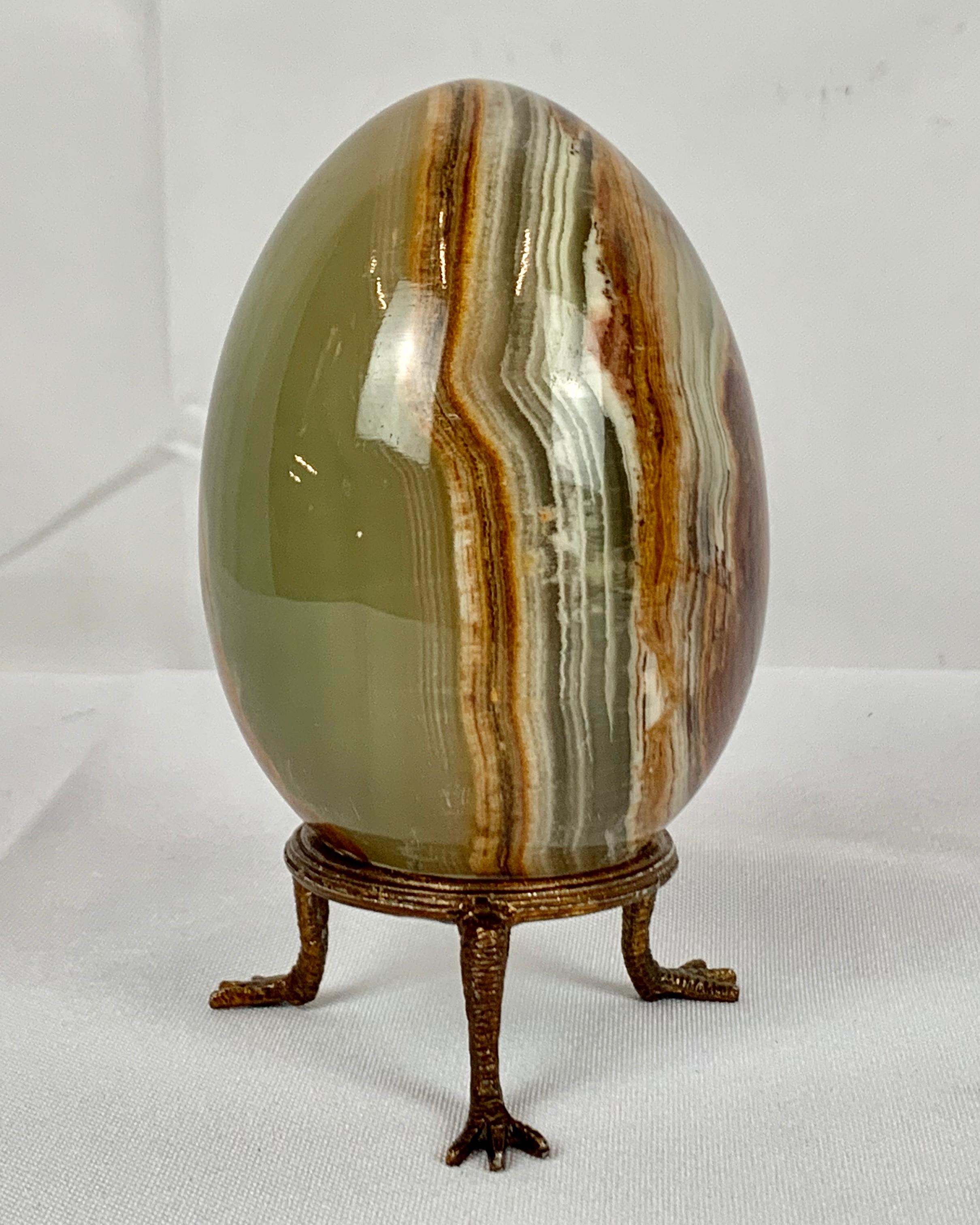 Handsomely marked natural onyx egg on a gilt three legged stand with bird feet.
Purchased by the owner and kept in a case since the 1970's.
Measures: Height-4.75
Diameter-3