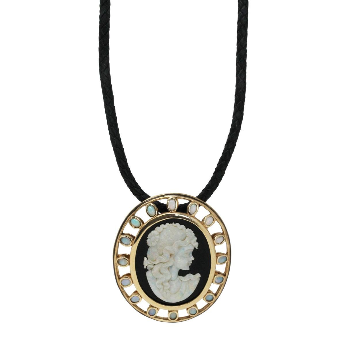 Material: 14k yellow gold
Gemstone Details: Black onyx with opal cameo measuring approximately 1.68″ x 1.18″ and bezel set opals measuring approximately 5.40mm x 3.87″ each.
Necklace Measurements: Leather cord necklace measures 23″ in length
Pendant