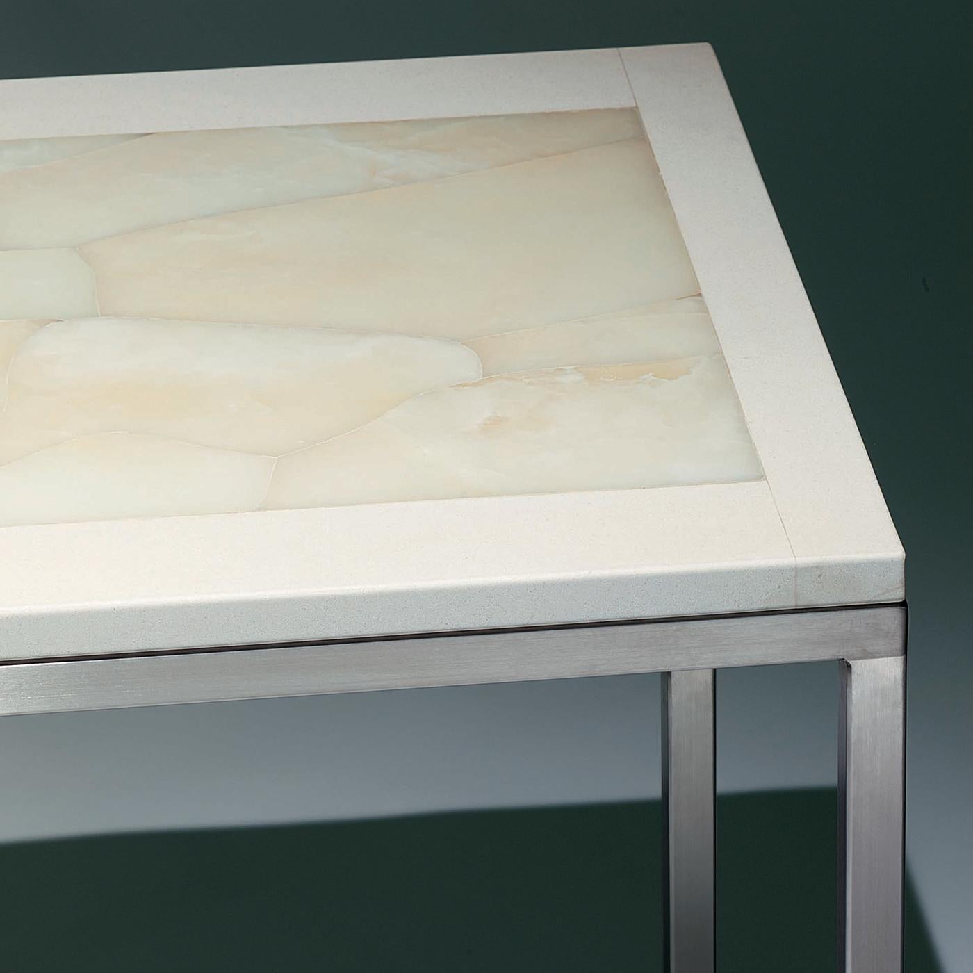 This large table will fit into any clean-styled, interior, including a dining room, living room, office, reception area or event venue. Its top is hand inlaid in white onyx trimmed in ivory-colored limestone. Its matte, smooth surface stands in