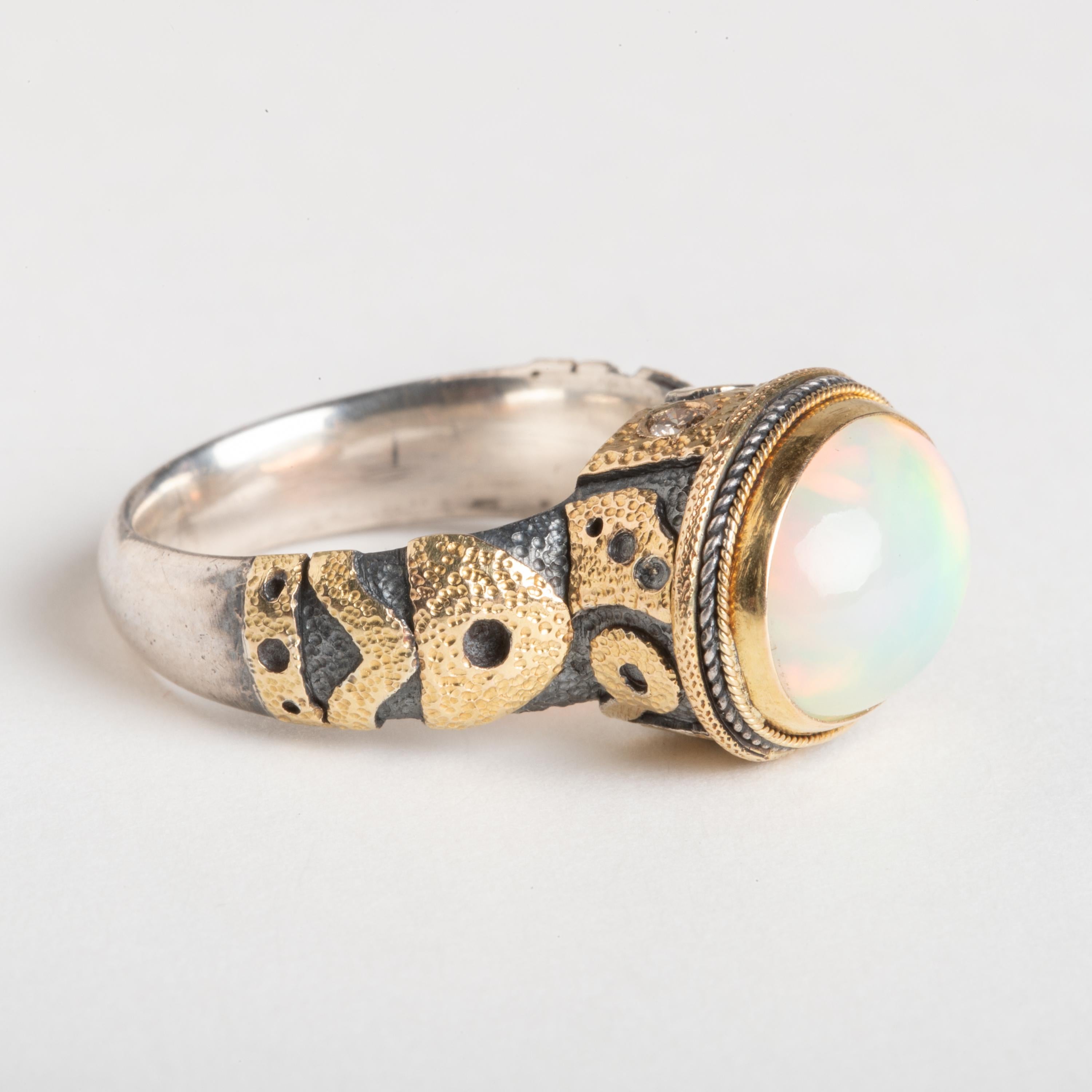 A beautiful large center opal with nice fire with two faceted round diamonds on the sides of the setting.  Set in a combination of 18K gold and sterling silver.  This is a weighted gold, not plated.  Ring size is 6.75.  Carat weight of opal is 2.88.