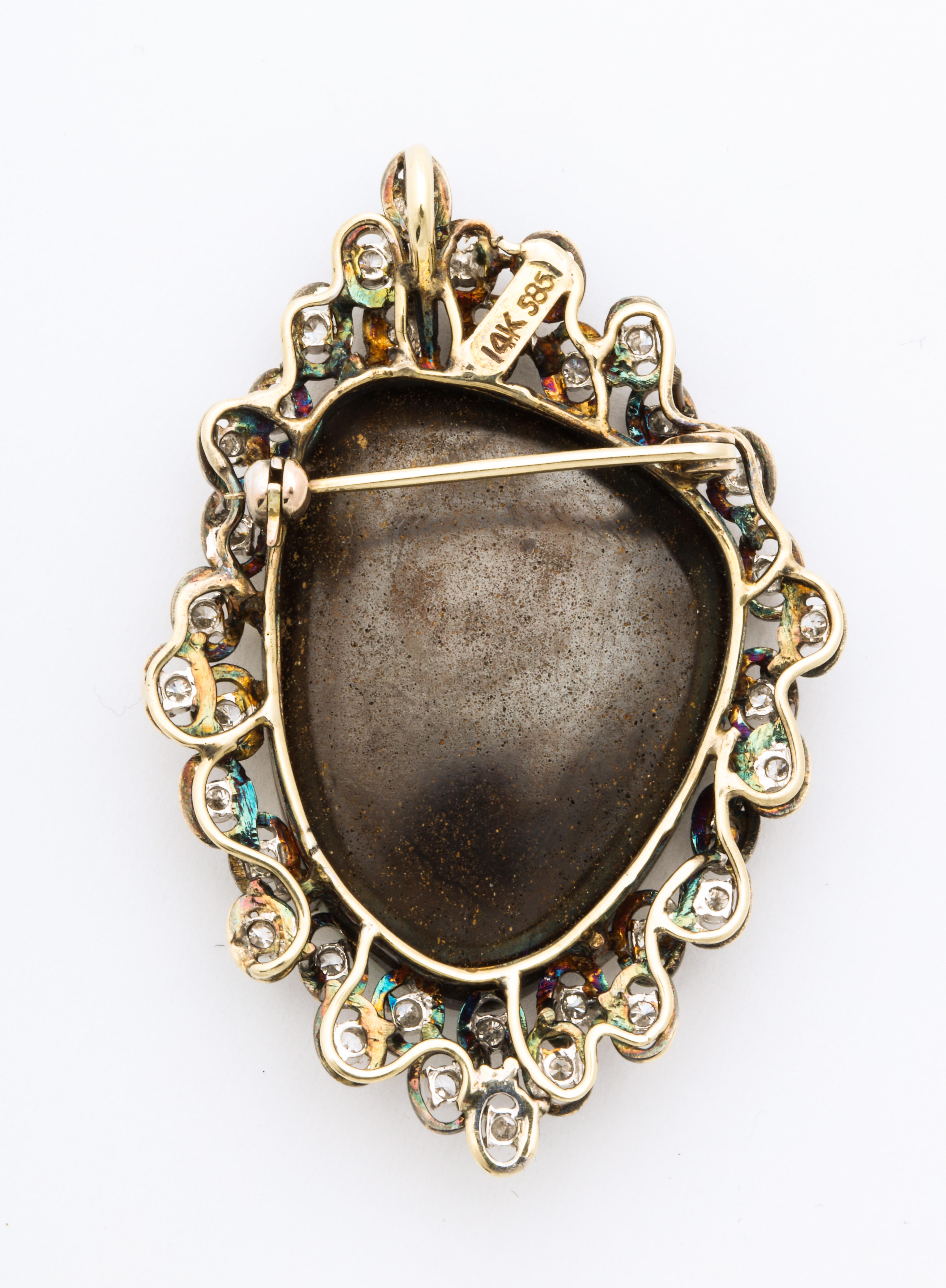 A fabulous large opal brooch/pendant surrounded by diamonds set in gold. This wonderful boulder opal that is set in 14k gold and surrounded by clustered diamonds in an asymmetrical configuration. It can be worn either as a brooch or as a pendant.
