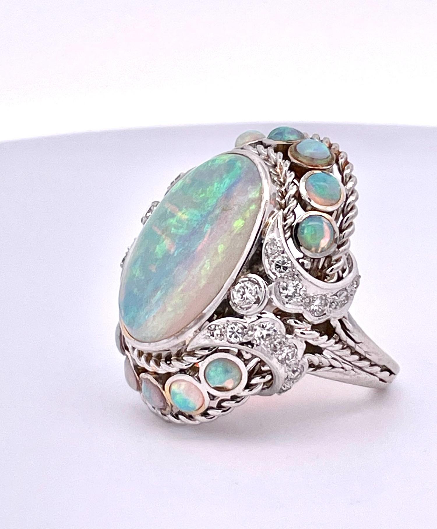 This Opal Ring is huge it measures 35mm x 30mm and has beautiful matrix of Blue, Pink, and Yellow.  This cocktail ring has an Opal of 19.82 x 14.82 x 12.90 deep and weighs in at 20.19 grams. It also has 12 smaller Opals of the same color around the