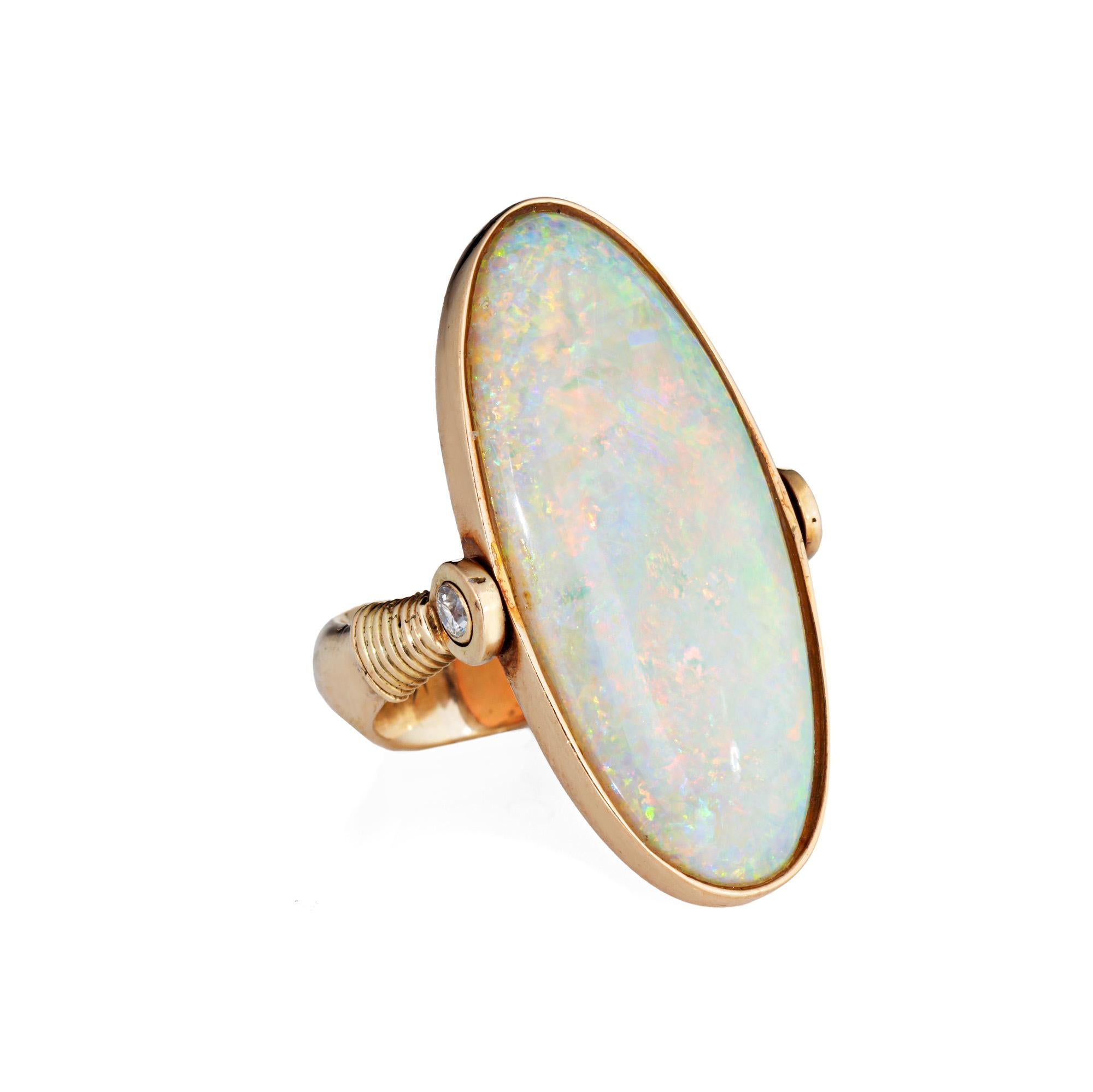 Stylish opal & diamond a'flip' ring crafted in 14 karat yellow gold (circa 1980s to 1990s).

Natural cabochon cut opal measures 32mm x 14mm (estimated at 14 carats). Two small estimated 0.02 carat diamonds adorn the side shoulders (0.04 ctw - H-I