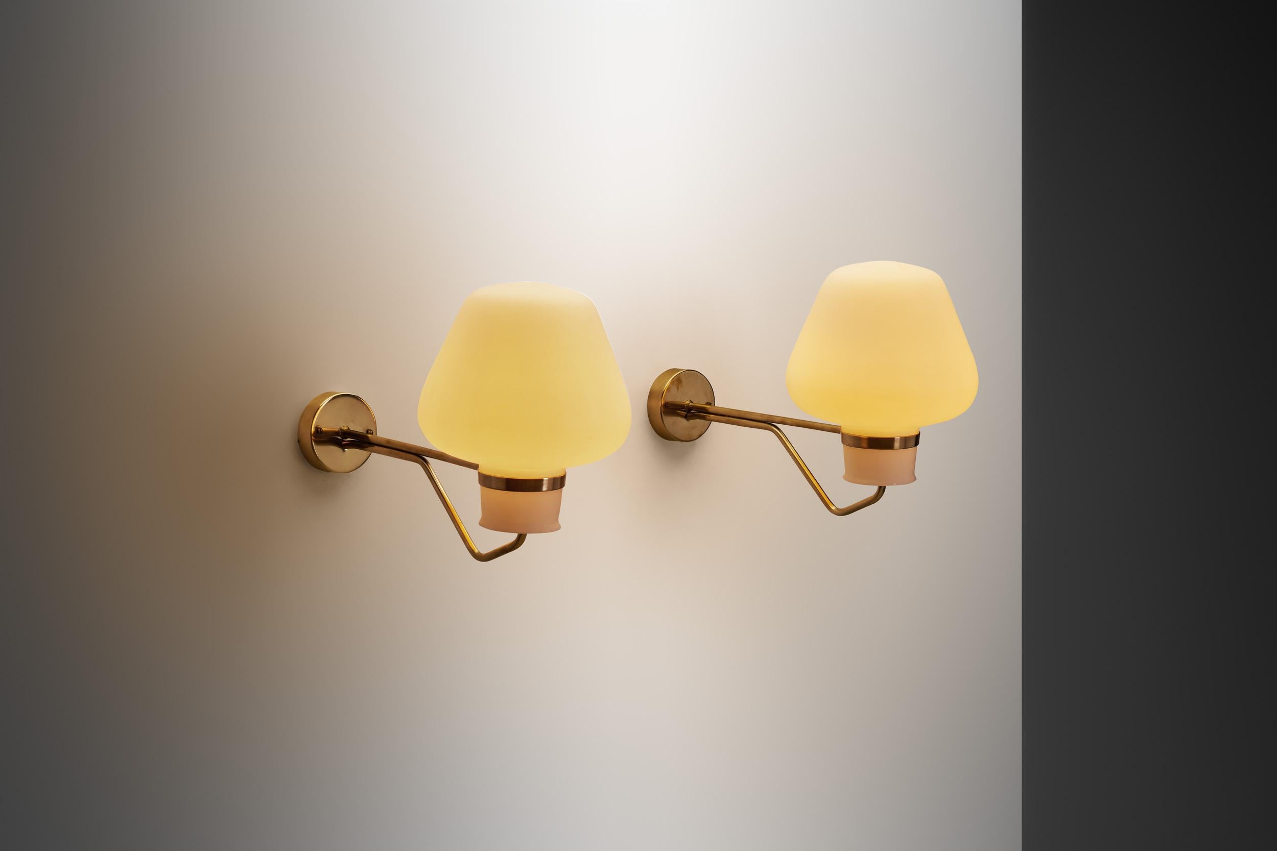 In the annals of mid-century modern design, the Swedish designer and architect, Gunnar Asplund stood out as a luminary, and his delicately sculptural creations, such as this pair of wall lamps from the 1950s, epitomize the era's sophistication and