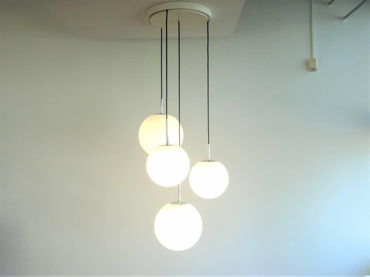 Questo lampadario o set di lampade a sospensione è stato disegnato per Glashütte Limburg, in Germania, negli anni '70. Ha 4 globi di vetro opalino soffiato a mano, 2 con un diametro di circa 30 cm e 2 con un diametro di circa 25 cm. Tutti con