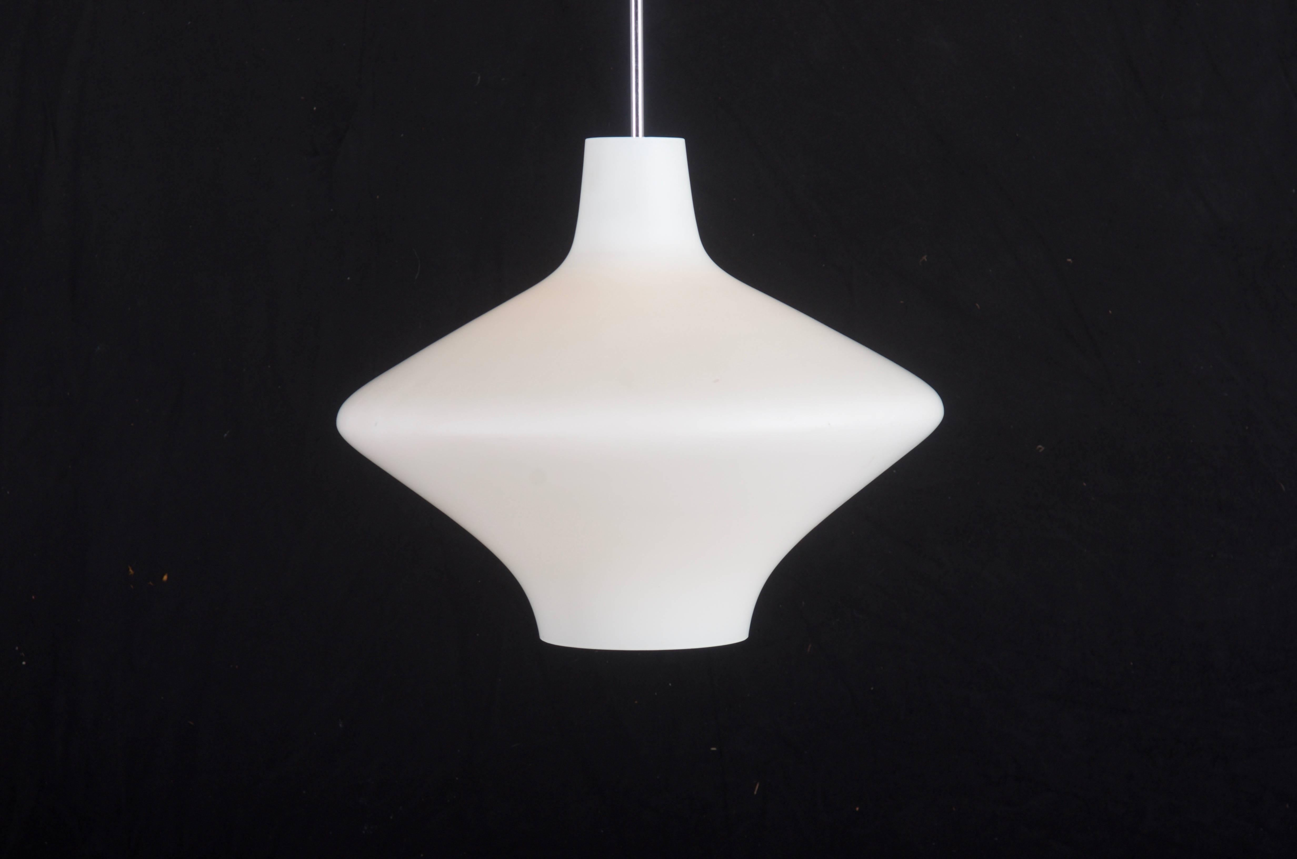 Paralume in vetro opalino bianco su pendolo in acciaio cromato dotato di una presa E27, degli anni '60.
L'altezza del bicchiere è di soli 37 cm (14,56