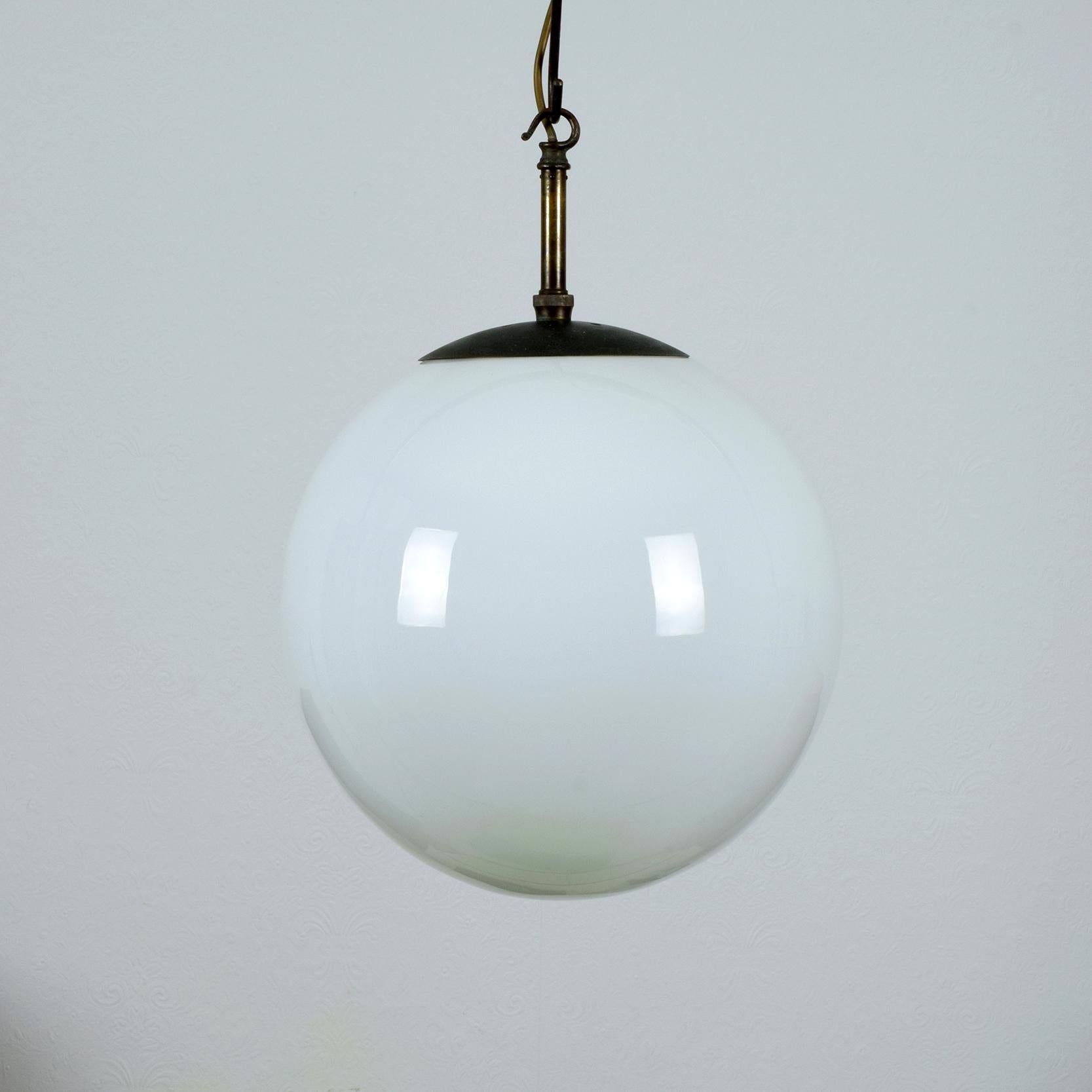 Beautiful 1920s white opaline glass globe pendant lamp.
Heavy high quality aged and patinated brass fittings.

Provenance: Hove Museum & Art Gallery, Brighton and Hove City, UK. The lamp dates from when the Museum was opened in 1927.

The lamp
