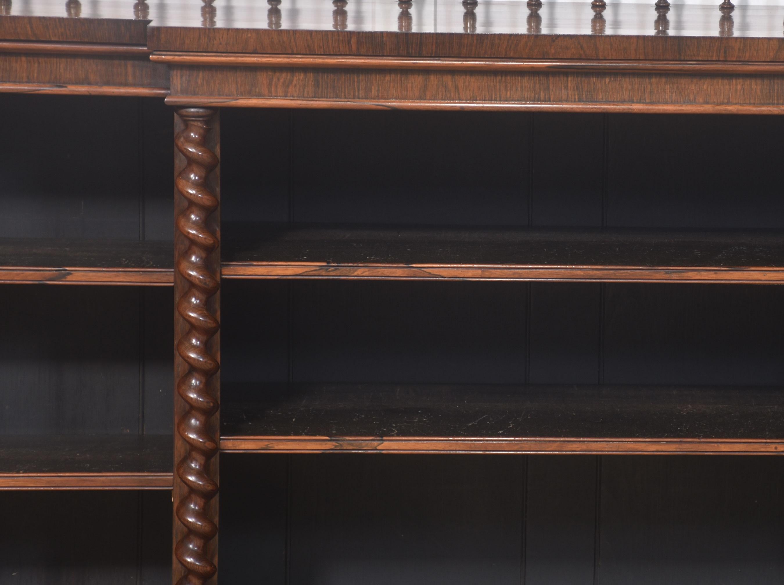 Rosewood open bookcase, the large rectangular breakfront top having raised spindle gallery, above three bays of adjustable shelves, divided by twisting pilasters. All are raised on a plinth base.
Dimensions
Height 40 Inches
Width 72.5 Inches
Depth