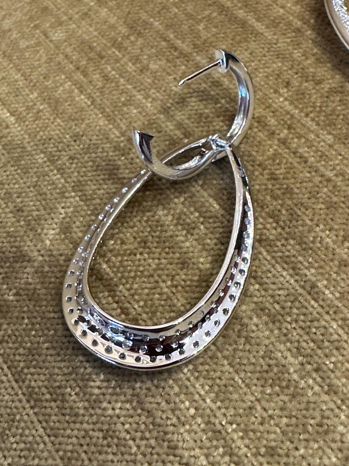Large Open Hoop Pave Diamond Earrings 3.05 carat total weight in 18k White Gold

Diamond Hoop earrings feature Large Teardrop Shaped Hoops with 3.05 carats in total of Round Brilliant Diamonds Pave set in 18k White Gold. The diamonds are lively, eye