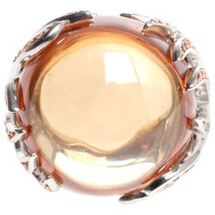 Large orange glass stone surounded by pink CZ