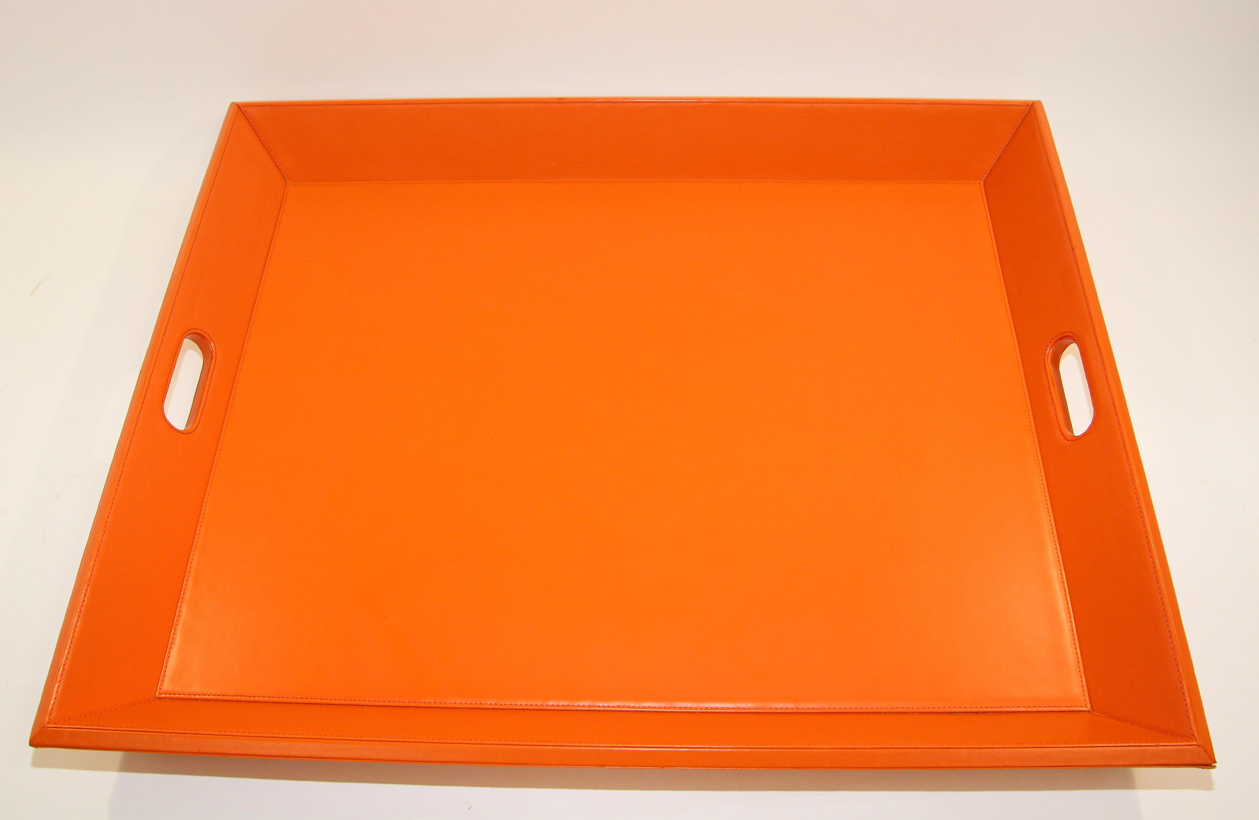 Large vintage orange tray with handles by Williams Sonoma Home
Large orange coffee table ottoman faux leather tray with handles.
The tray is made of faux leather with coordinated stitching and cut out handles at each end make it easy to move the