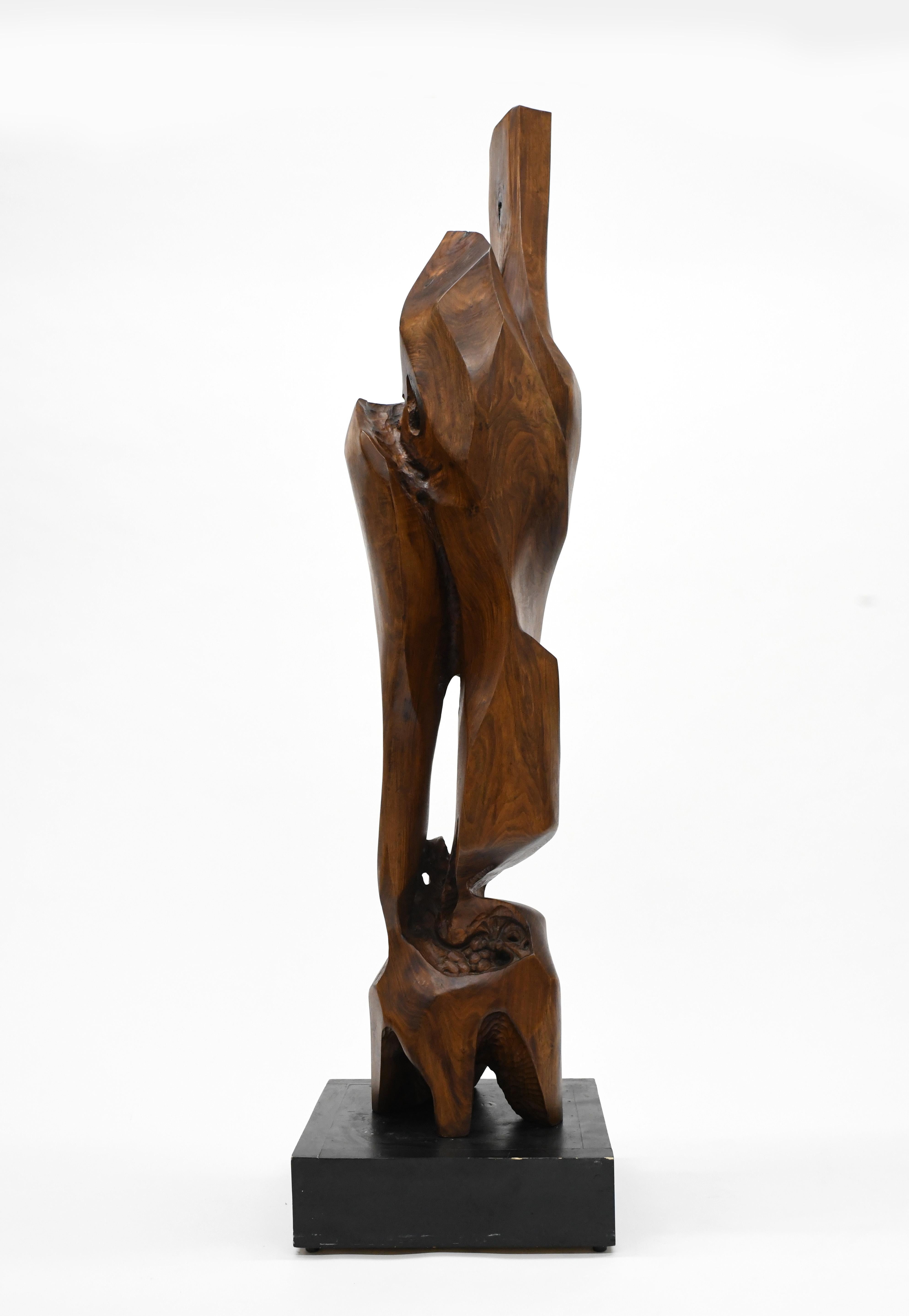 Exceptional abstract wood sculpture made from one piece of solid black walnut. Sculpture is signed D. Gibbins and dated 1986. Black painted wood pedestal is included. Condition is excellent. Measurements are 64