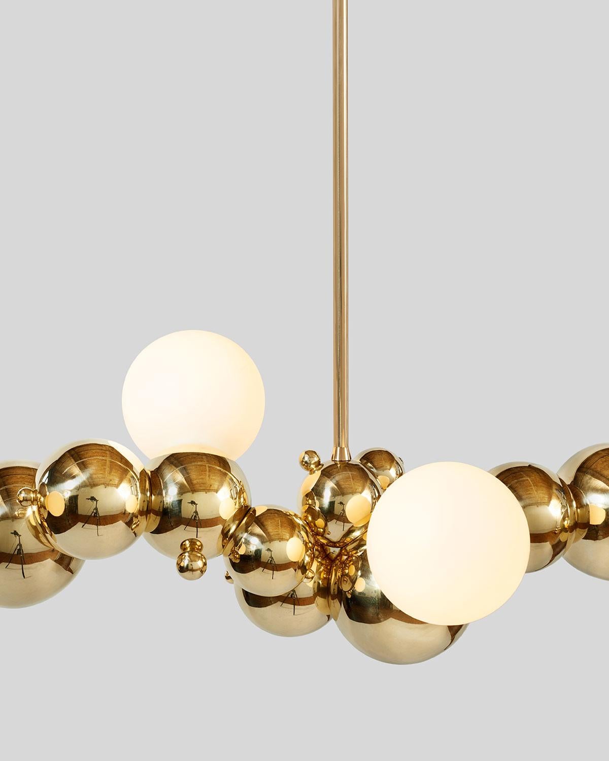 Large, organic chandelier with four lights made of interlocking spun brass spheres, from Rosie Li's 