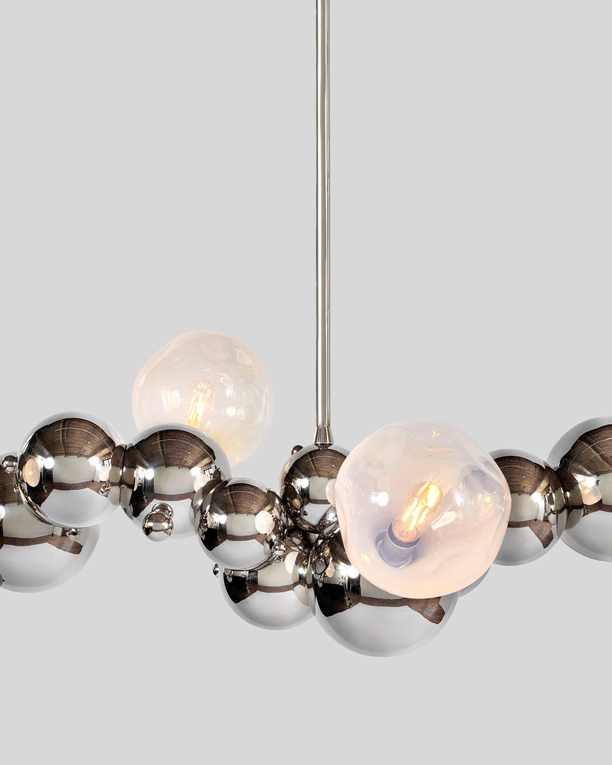 Large, organic chandelier with four hand blown glass lights made of interlocking spun brass spheres, from Rosie Li's 