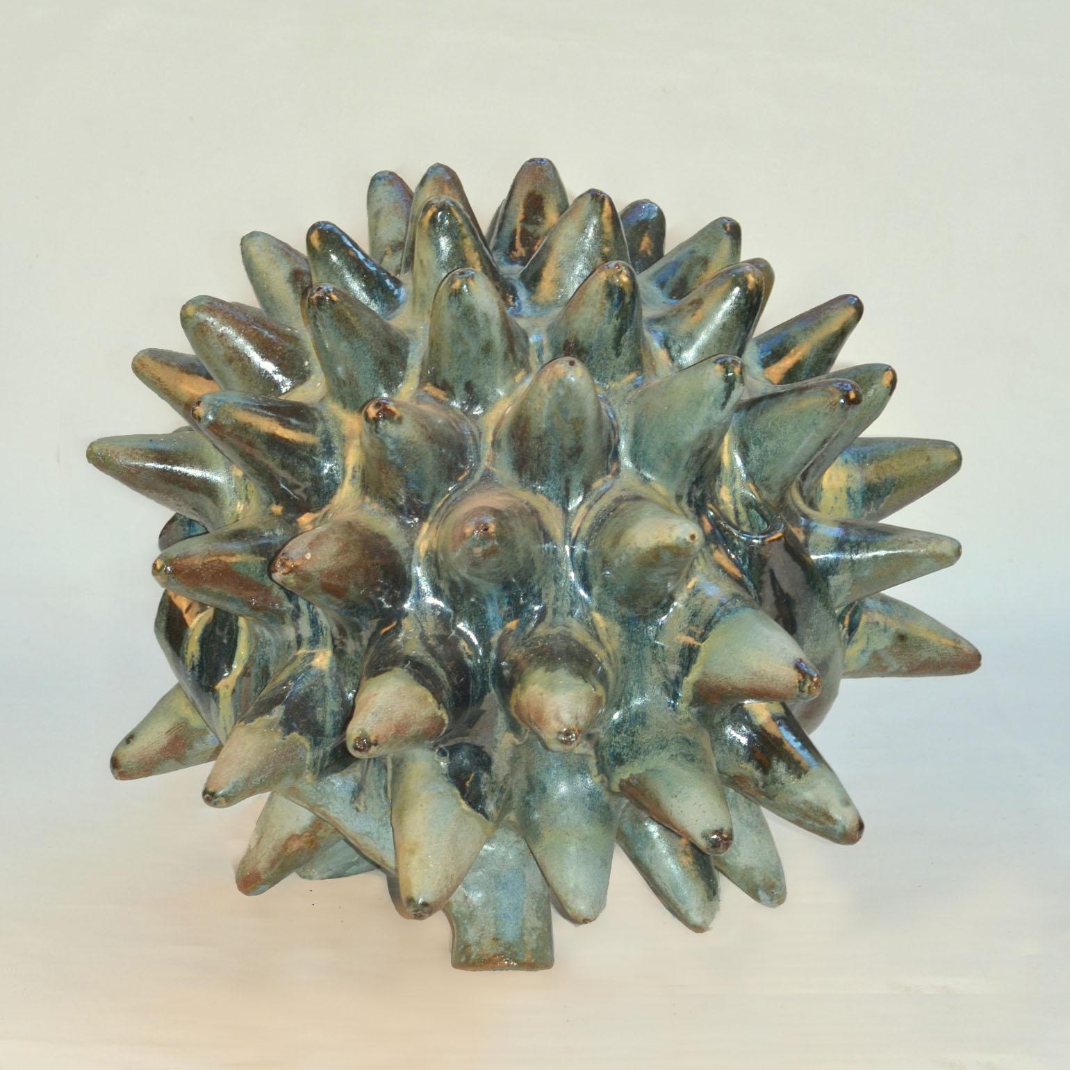 Large organic floor sculpture sculpted by the South American artist Fernando Marquina looks like an armored creature from the natural world of the Jurassic period. It is characterized by the distinctive circular cone shaped upright spikes around its